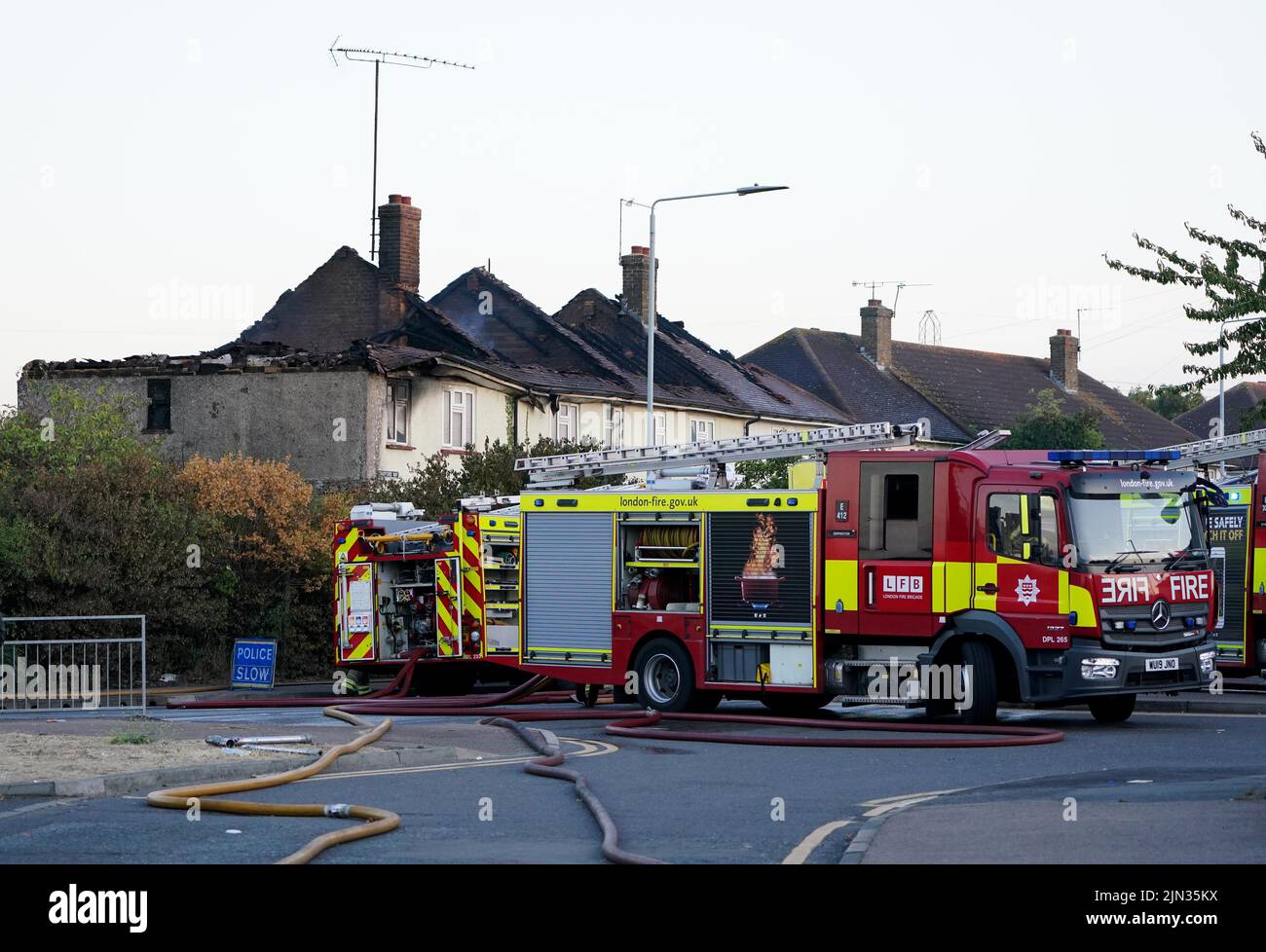 Servicios de emergencia en la escena en Crayford Way, Crayford, al sureste de Londres, donde los bomberos han estado enfrentando un incendio que rasgó a través de cuatro casas adosadas Fecha de la foto: Lunes 8 de agosto de 2022. Foto de stock