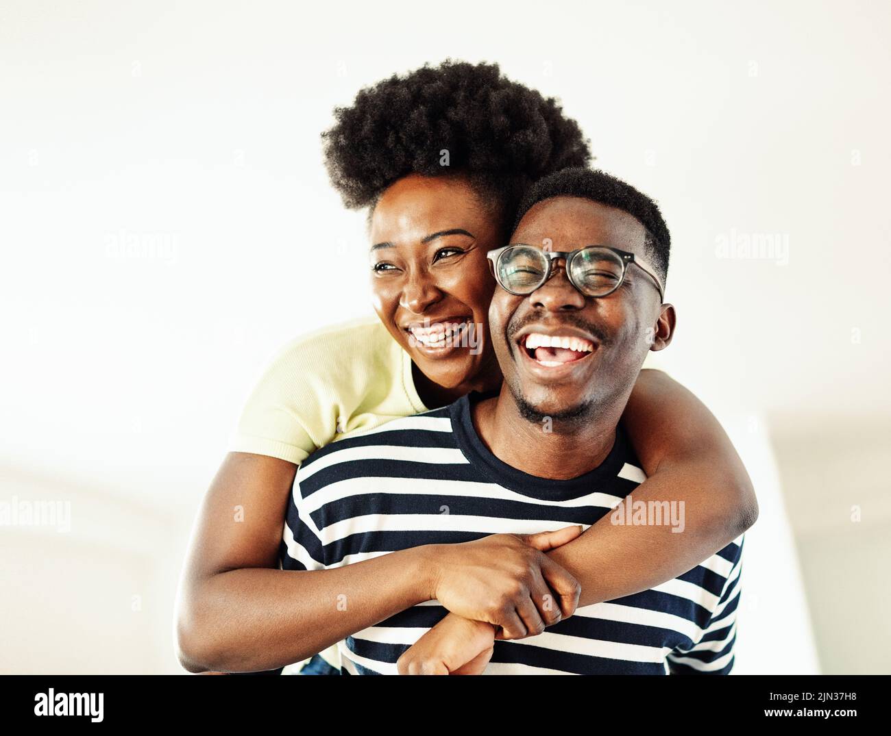 Retrato de una pareja joven encantadora divertirse y reírse juntos piggyback en casa Foto de stock