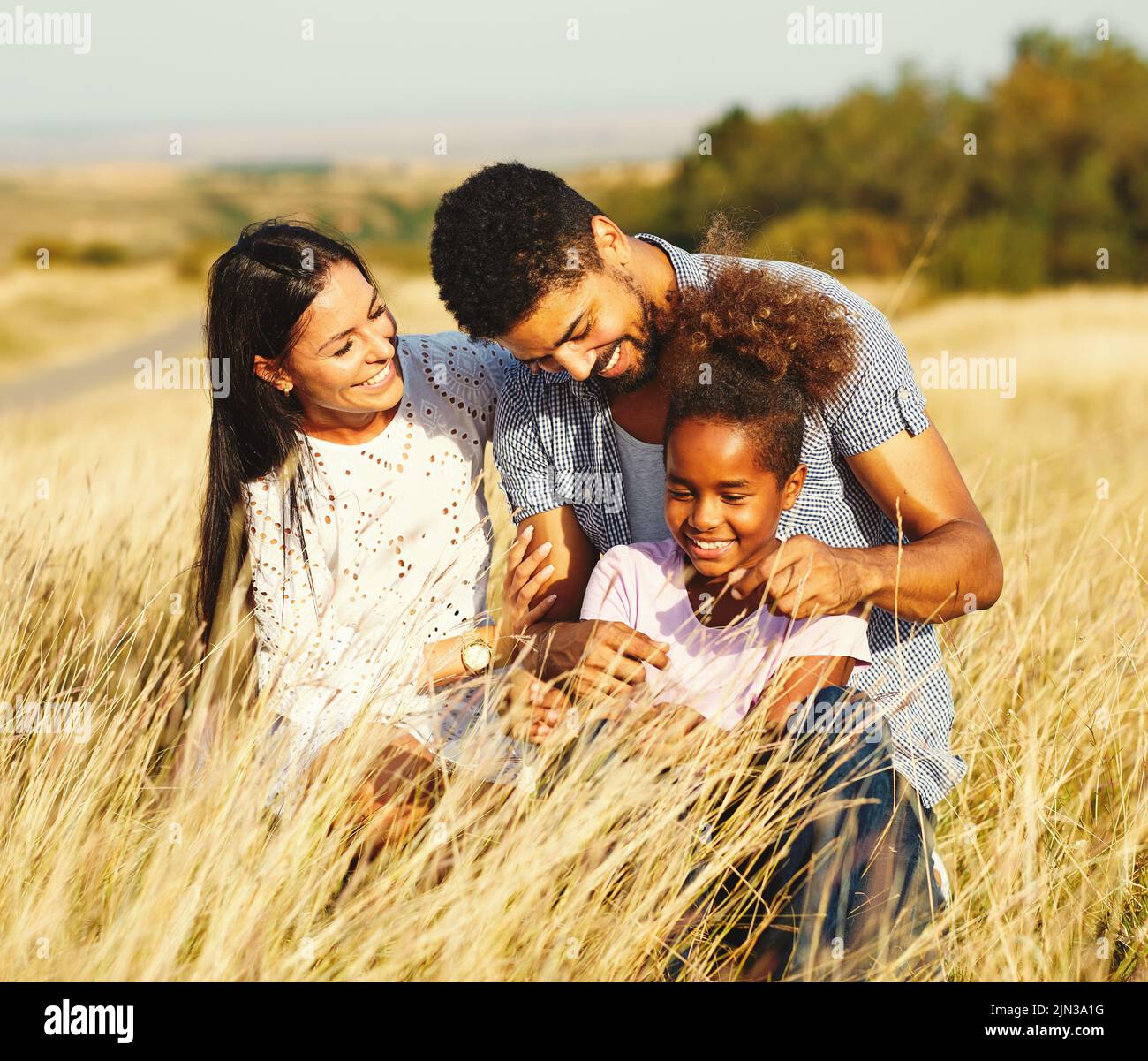 niño hija familia feliz madre padre sano despreocupado diversión junto chica alegre campo al aire libre natur retrato de verano Foto de stock