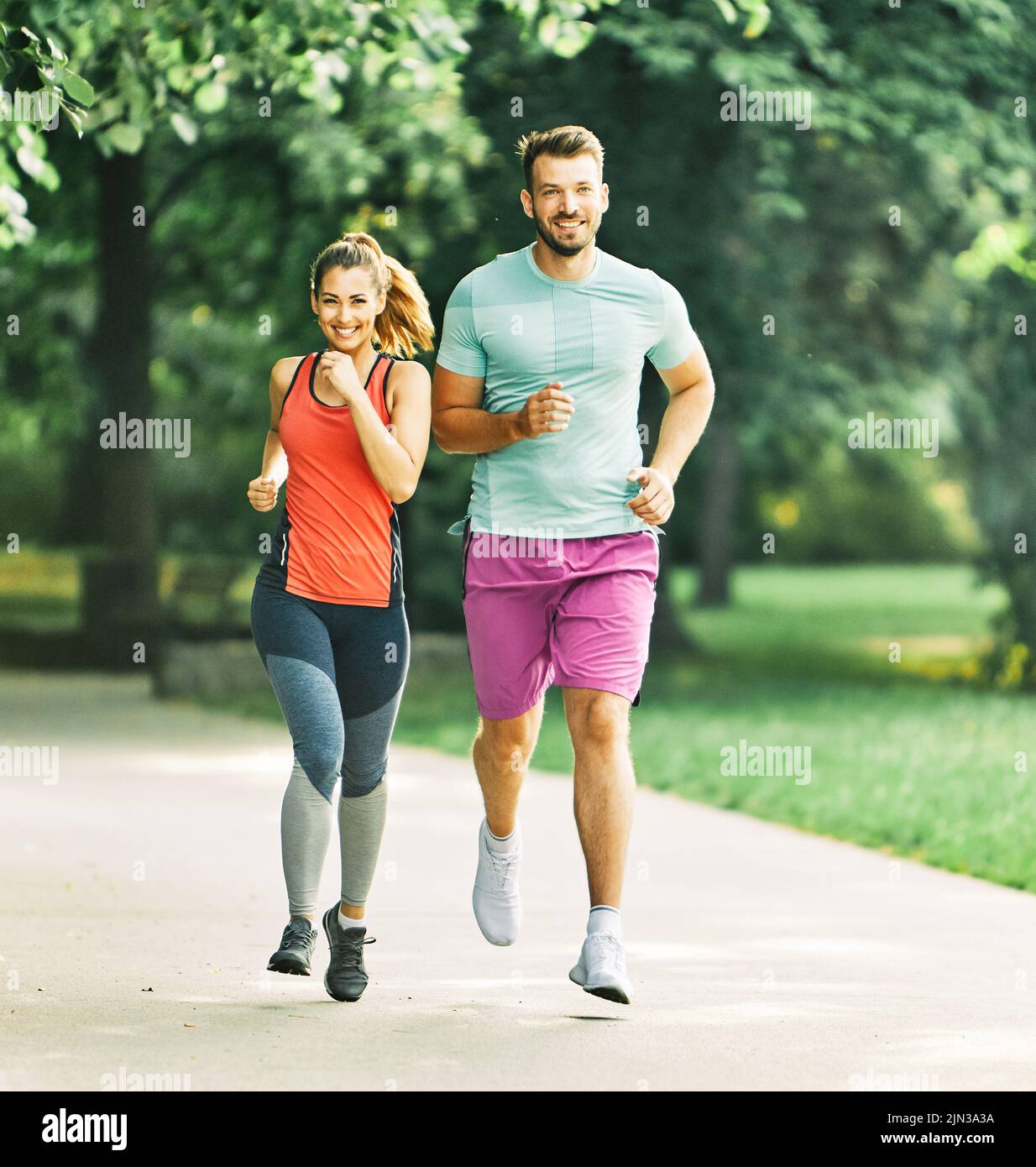 gimnasio mujer parque ejercicio estilo de vida al aire libre deporte pareja saludable naturaleza activo joven en forma de entrenamiento atleta hombre Foto de stock