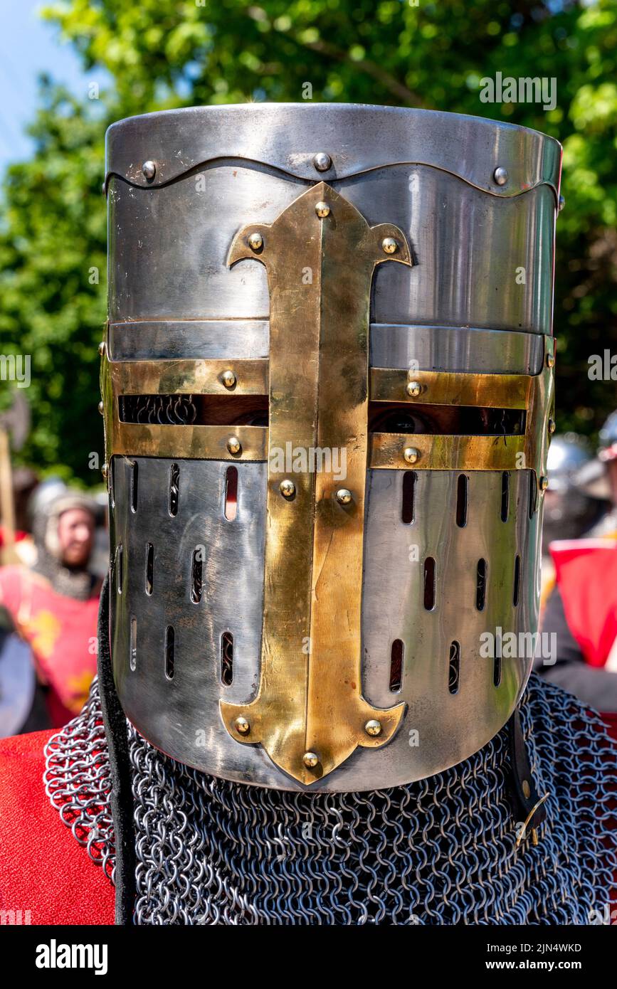 Un hombre vestido de traje medieval se prepara para participar en Un re-compromiso de la Batalla de Lewes , Lewes, East Sussex, Reino Unido Foto de stock