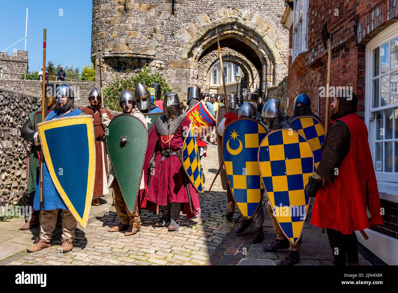 Los hombres vestidos con trajes medievales se preparan para participar en Una re-incorporación de la Batalla de Lewes en las afueras del castillo del siglo 13th, Lewes, East Sussex, Reino Unido Foto de stock