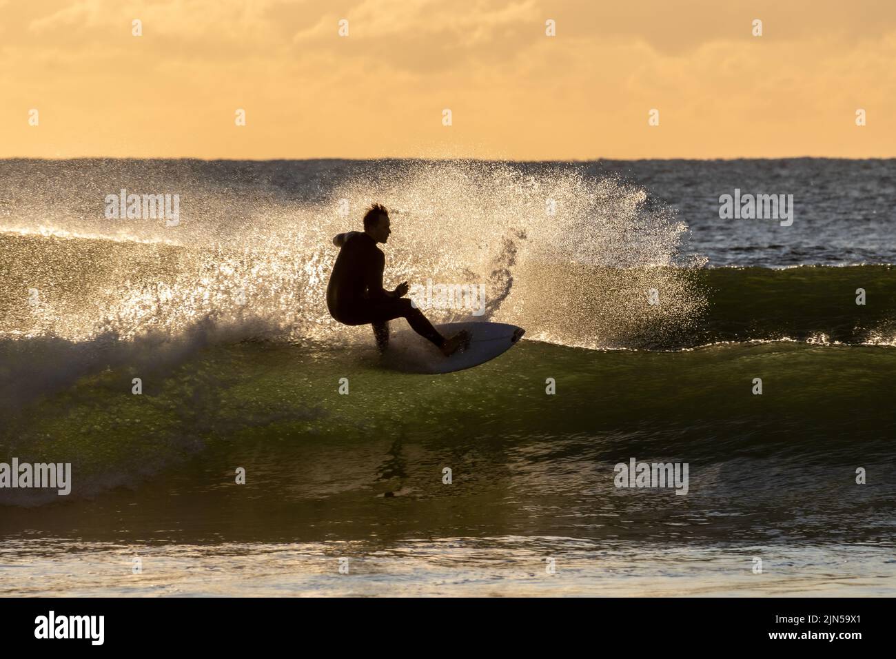 El surfista montando una ola por la mañana temprano. Maroochydore, Australia. Foto de stock