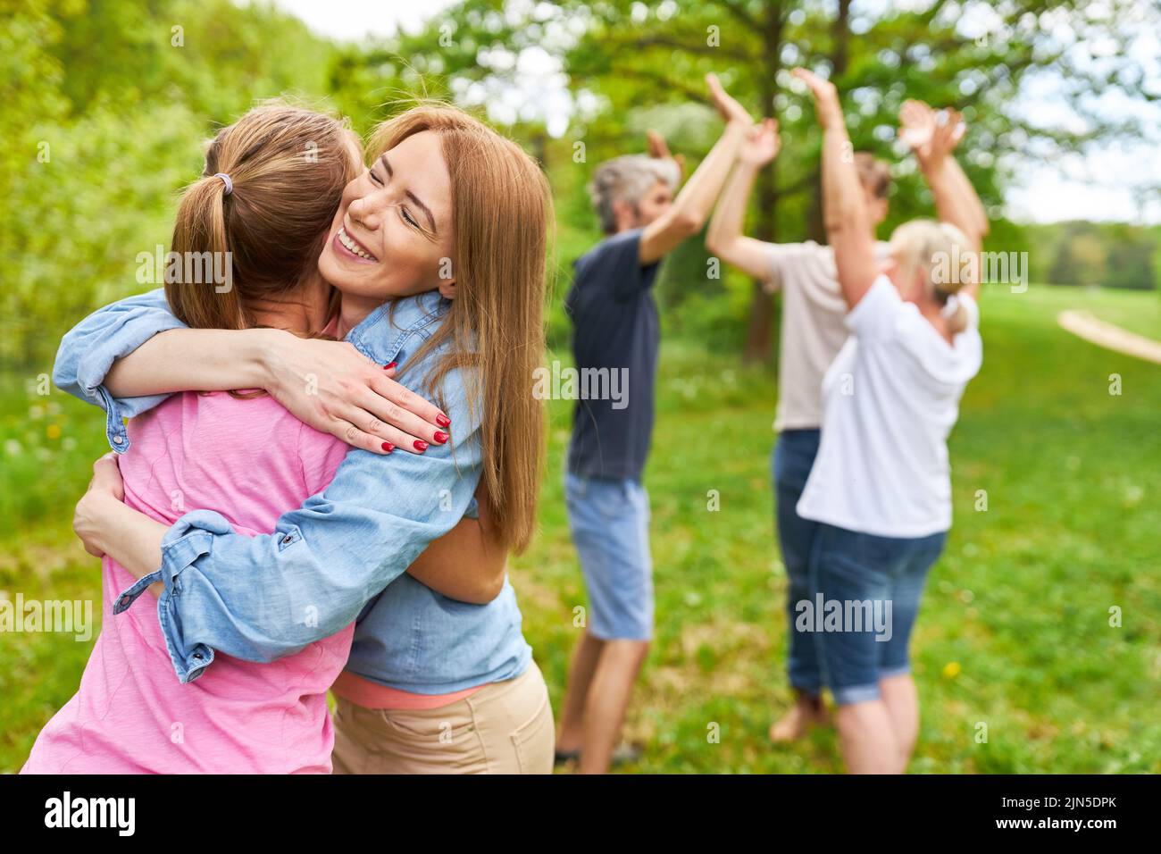 Dos mujeres se abrazan y se regocijan en el evento del equipo después de un éxito en la competencia Foto de stock