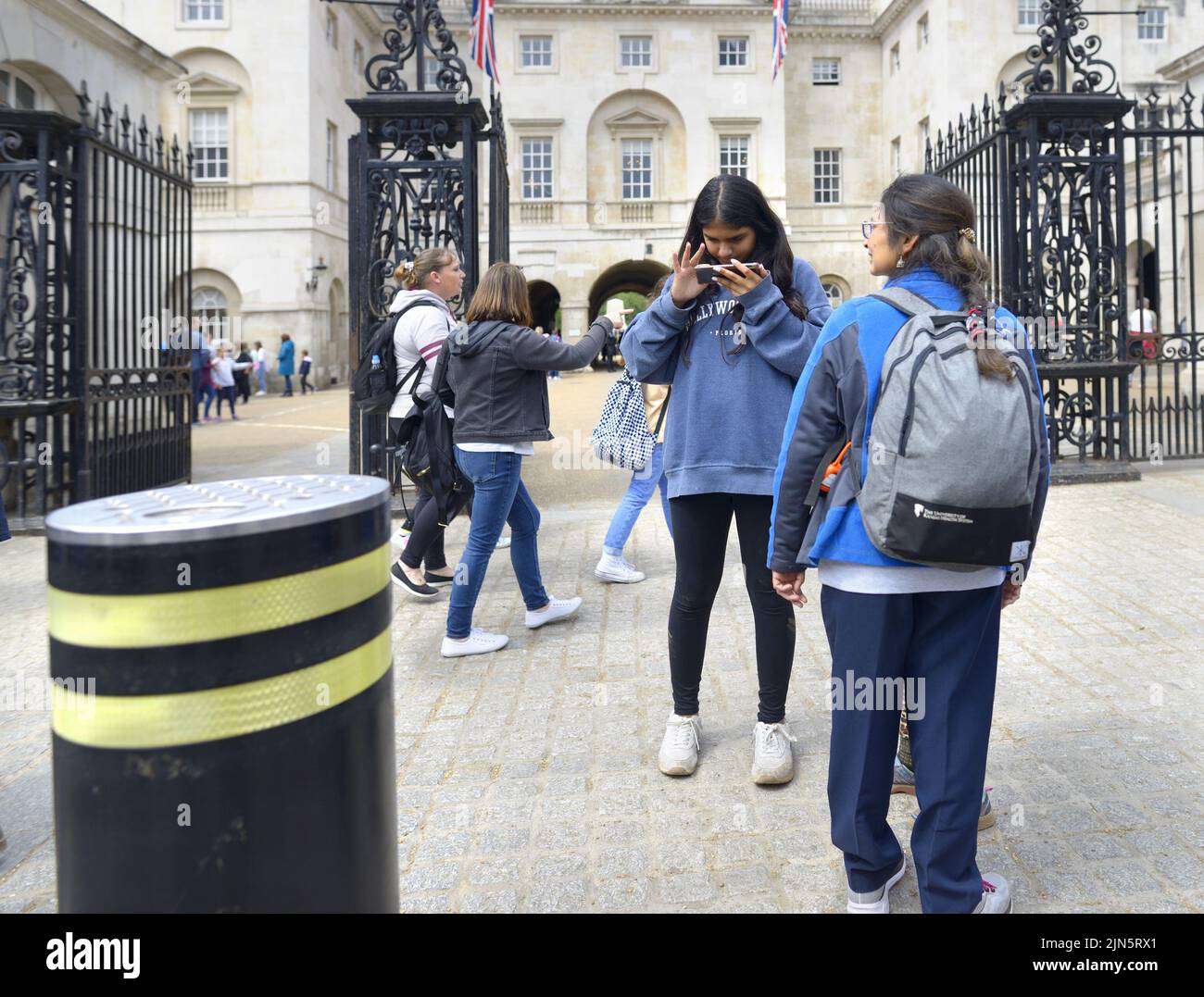 Londres, Inglaterra, Reino Unido. Chica mirando su teléfono móvil fuera de Horse Guards Parade en Whitehall Foto de stock