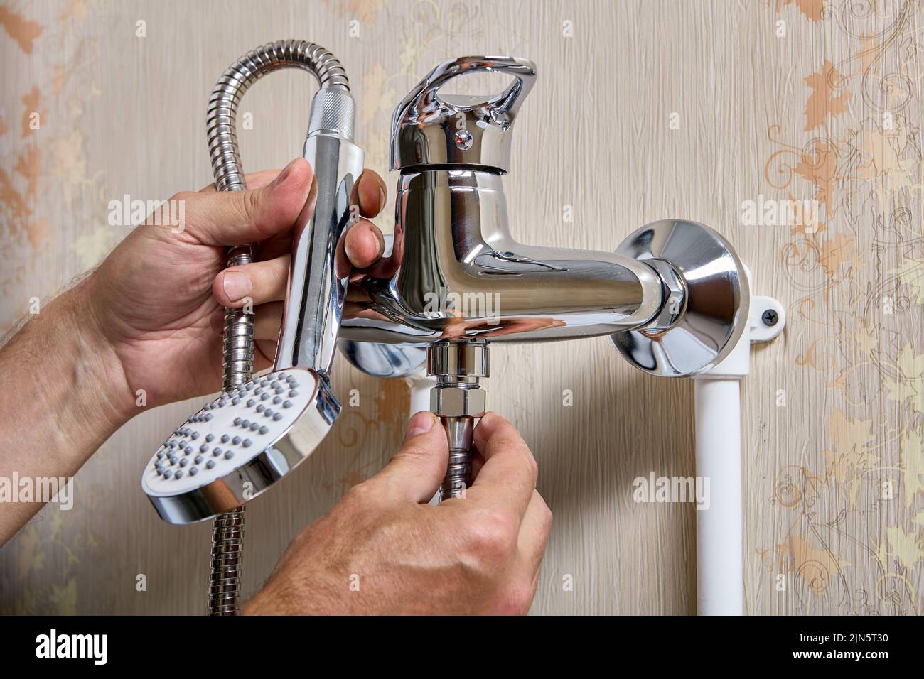 Cabezal de ducha con manguera flexible, tuerca de fijación de ajuste de fontanero. Foto de stock