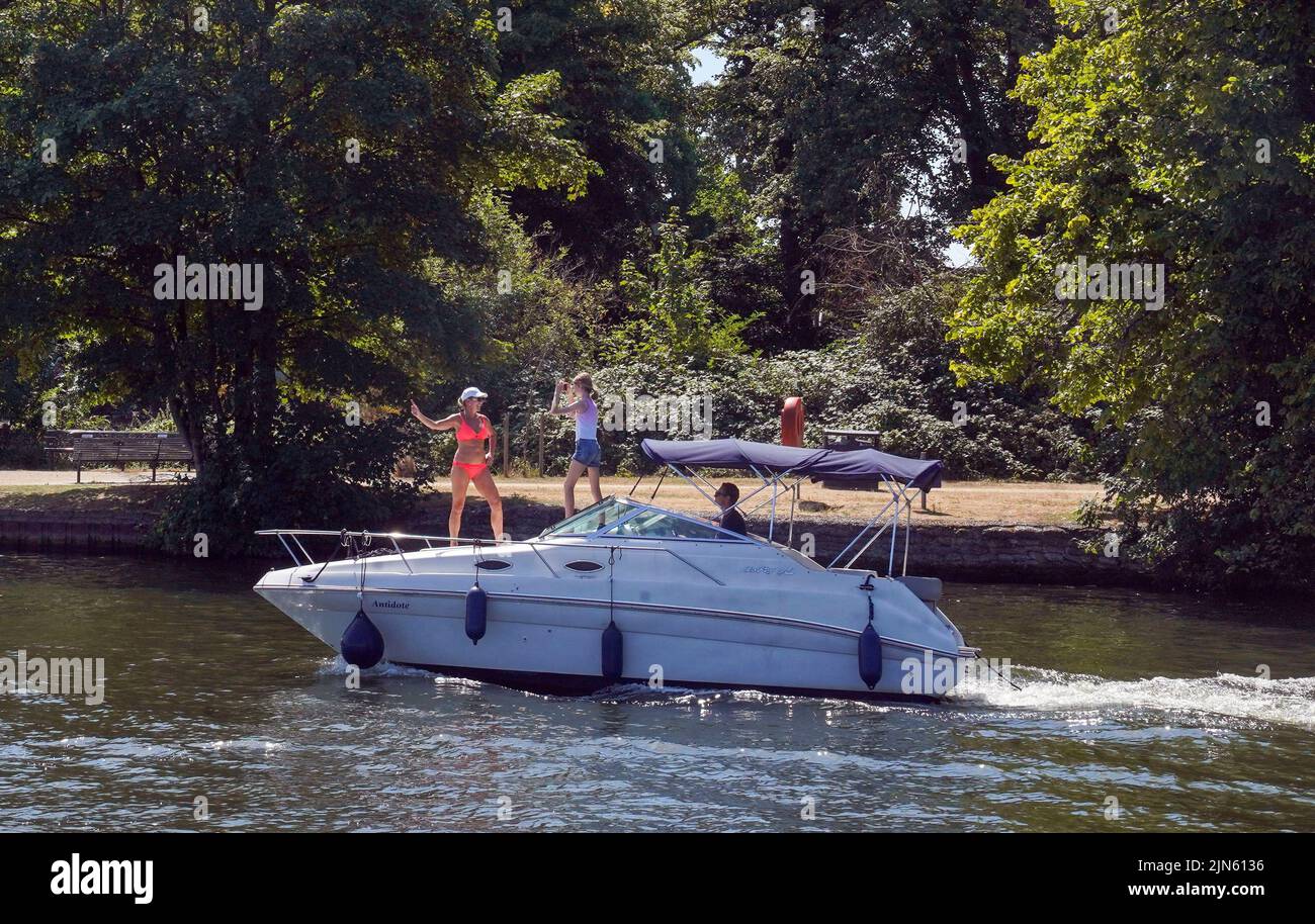 La gente en un barco en el río Támesis en Windsor, como un verano de prohibiciones de tubos de escape y advertencias de incendio continúa, con una alerta de salud por calor que entra en vigor en gran parte del país. Fecha de la foto: Martes 9 de agosto de 2022. Foto de stock