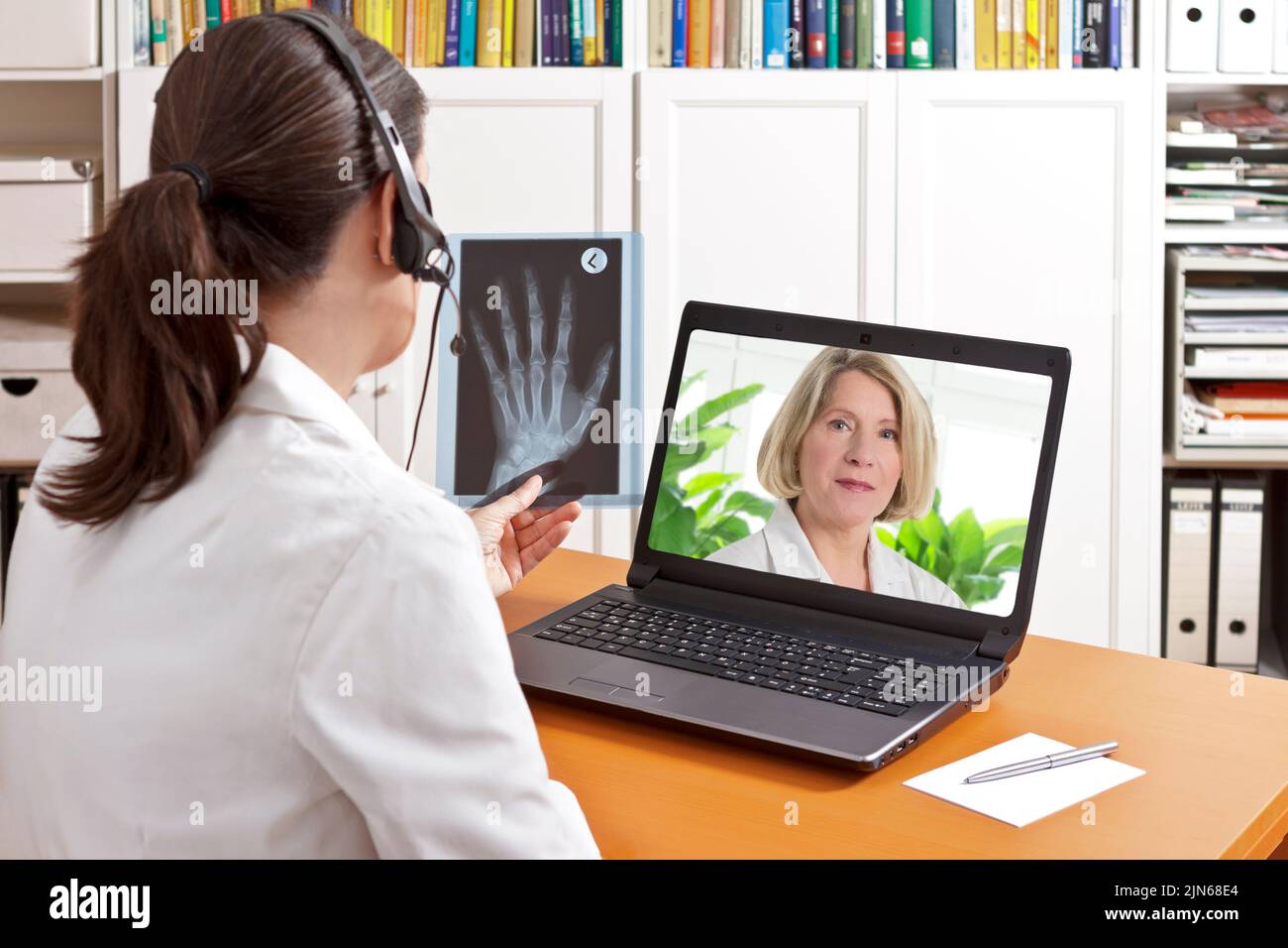 Concepto de telemedicina: Dos médicos o farmacéuticos durante una videoconferencia médica sobre los resultados de los rayos X. Foto de stock