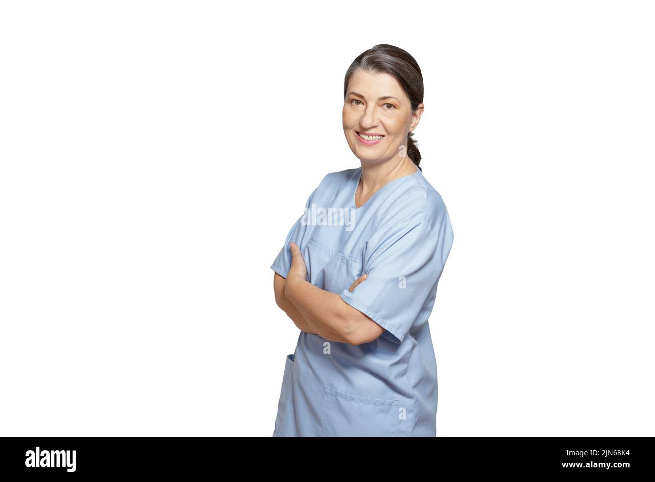 Amable enfermera madura sonriente en un matorral azul, aislado sobre fondo blanco, copia o espacio de texto. Foto de stock