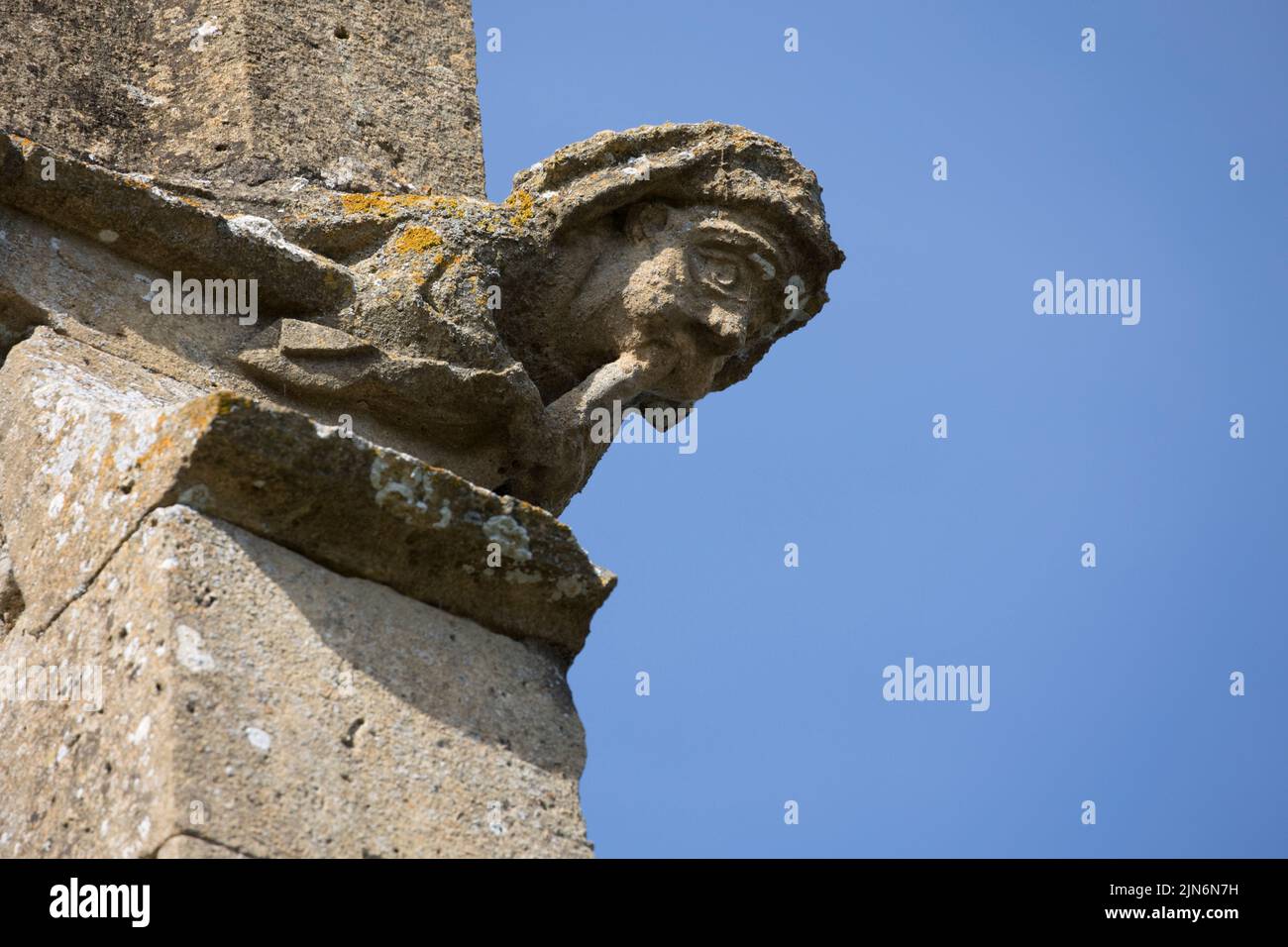 Gárgola antigua desgastada contra el cielo azul en All Saints Church Weston en Avon Warwickshire UK Foto de stock