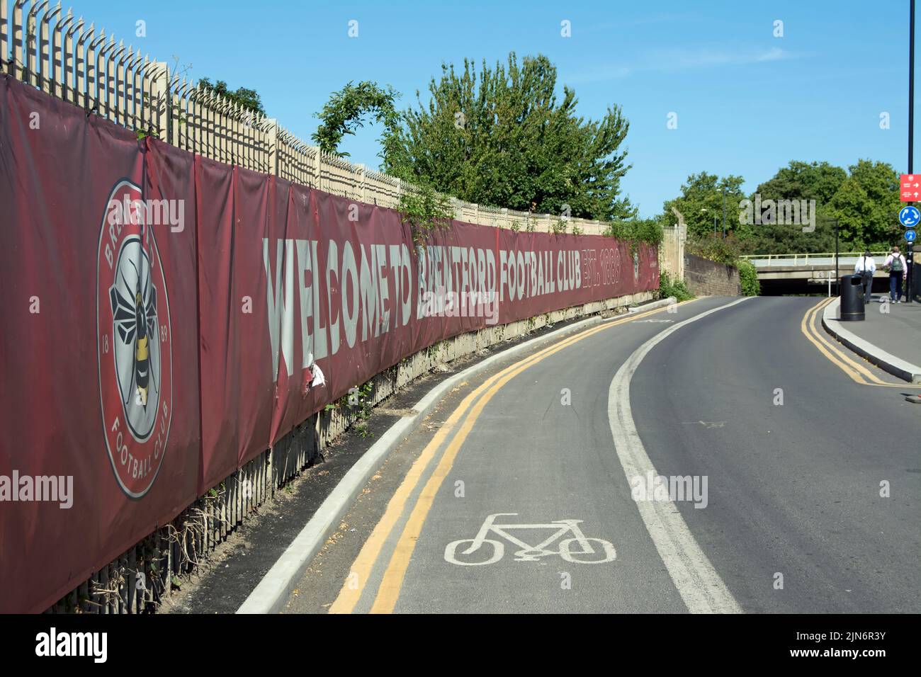 bienvenido a la bandera del club de fútbol de brentford junto a un carril bici, fuera del terreno del club, el estadio comunitario gtech, en el oeste de londres, inglaterra Foto de stock