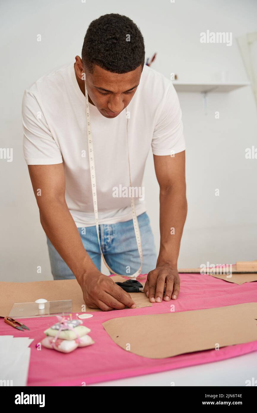 Hombre afroamericano haciendo ropa en atelier Foto de stock