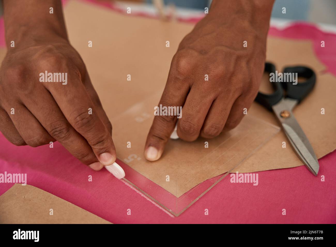 Hombre sastre haciendo patrones en la tela antes de coser Foto de stock