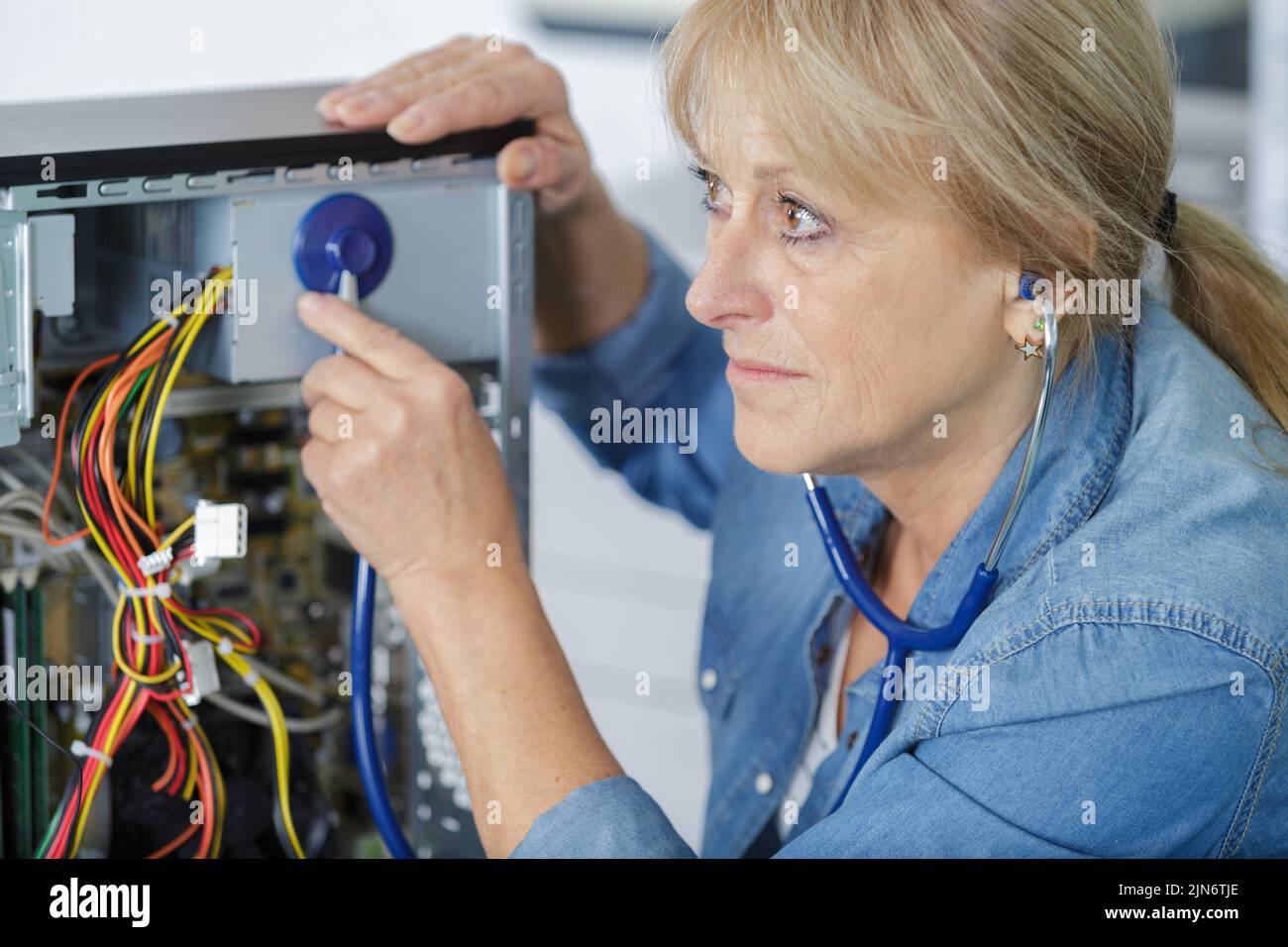 mujer de mediana edad arreglando pc Foto de stock