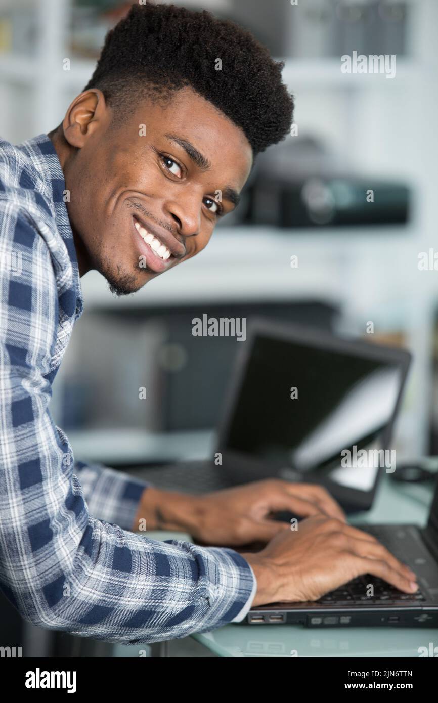 hombre feliz con portátil sobre fondo blanco Foto de stock