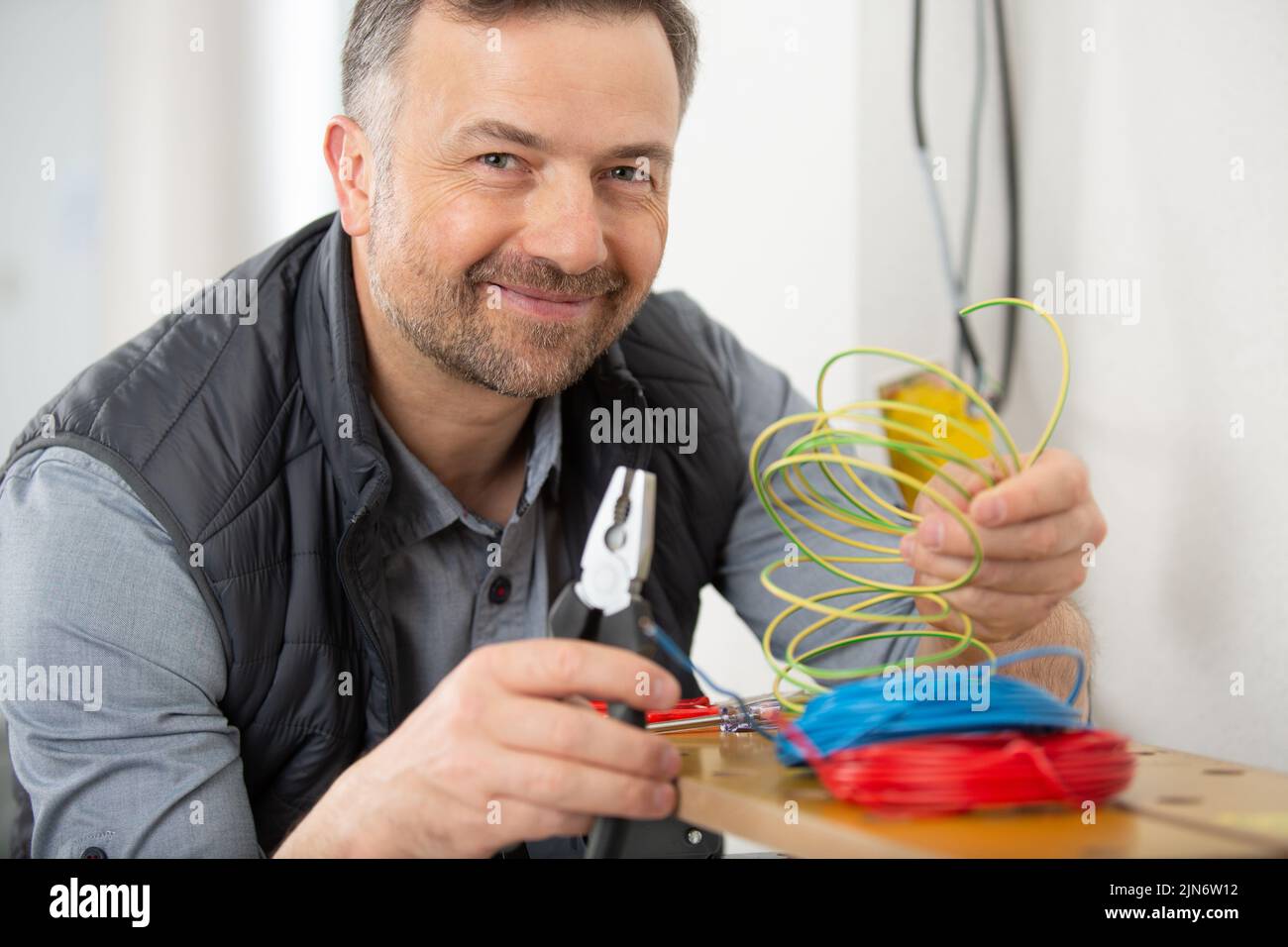 electricista trabajando con cables y ensamblando nuevo cableado Foto de stock