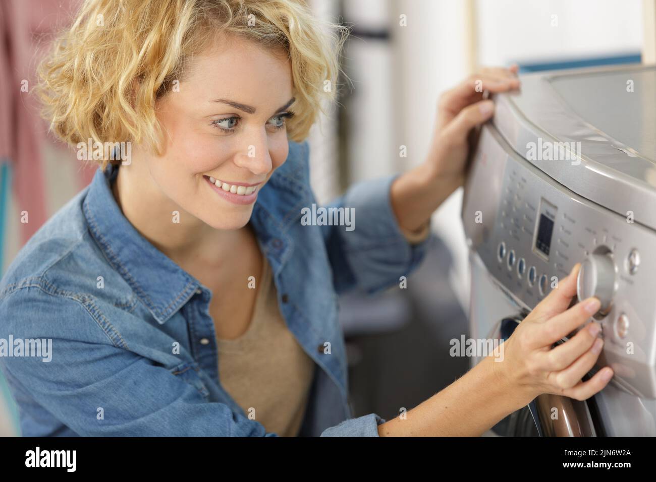 mujer preparando una lavadora Foto de stock