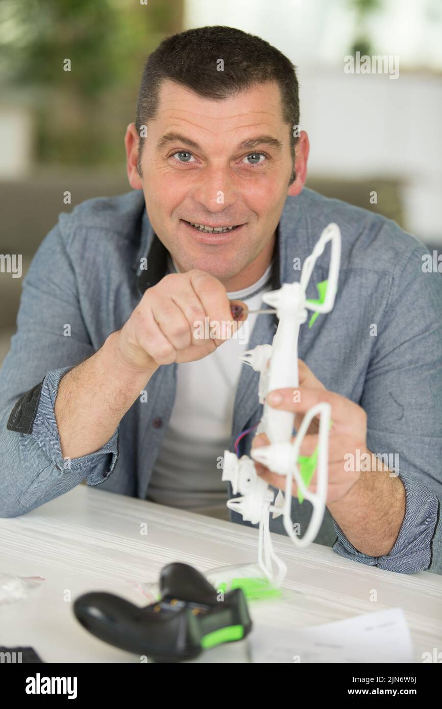 hombre maduro ensamblando un drone Foto de stock