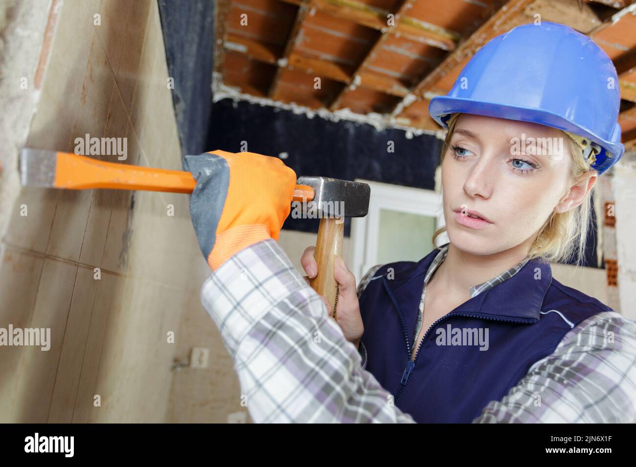 Mujer con martillo y cincel en el trabajo Foto de stock