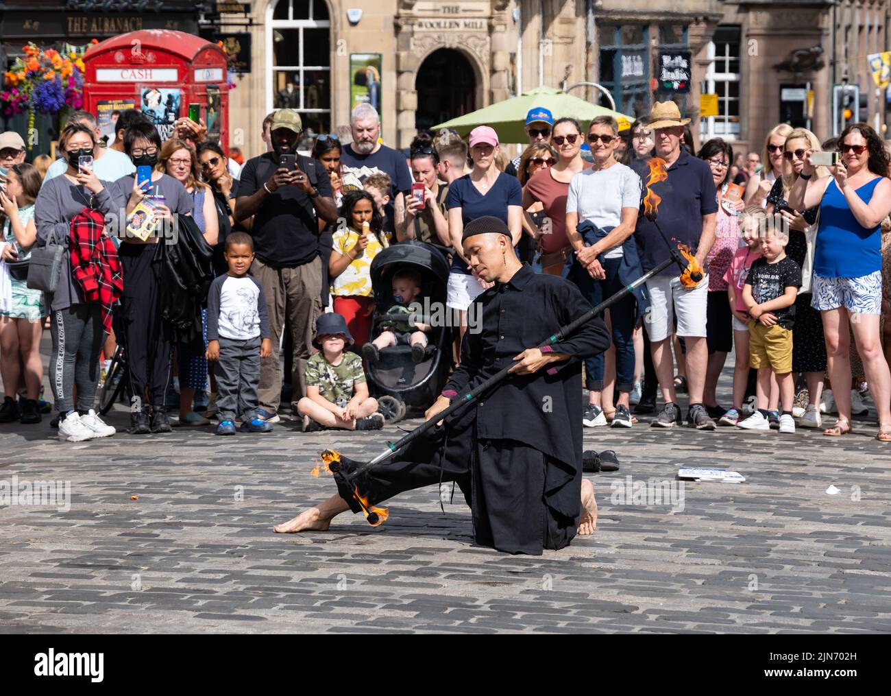 Royal Mile, Edimburgo, Escocia, Reino Unido, 9th de agosto de 2022. Festival de Edimburgo Fringe Street PERFORMER: Un hombre actúa para la multitud al sol jugando con fuego. Crédito: Sally Anderson/Alamy Live News Foto de stock