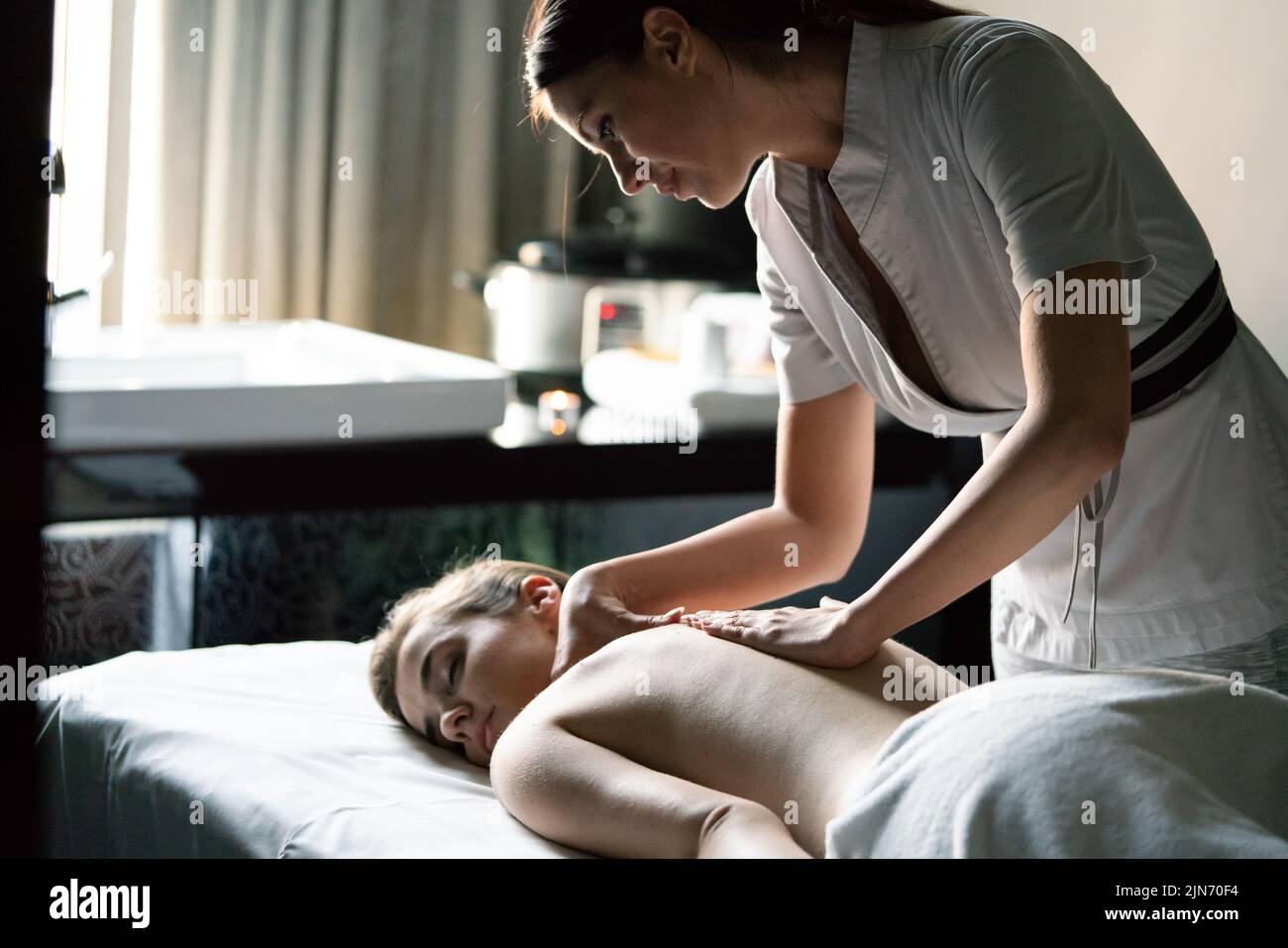 Hermosa mujer joven con masaje en el salón spa Foto de stock