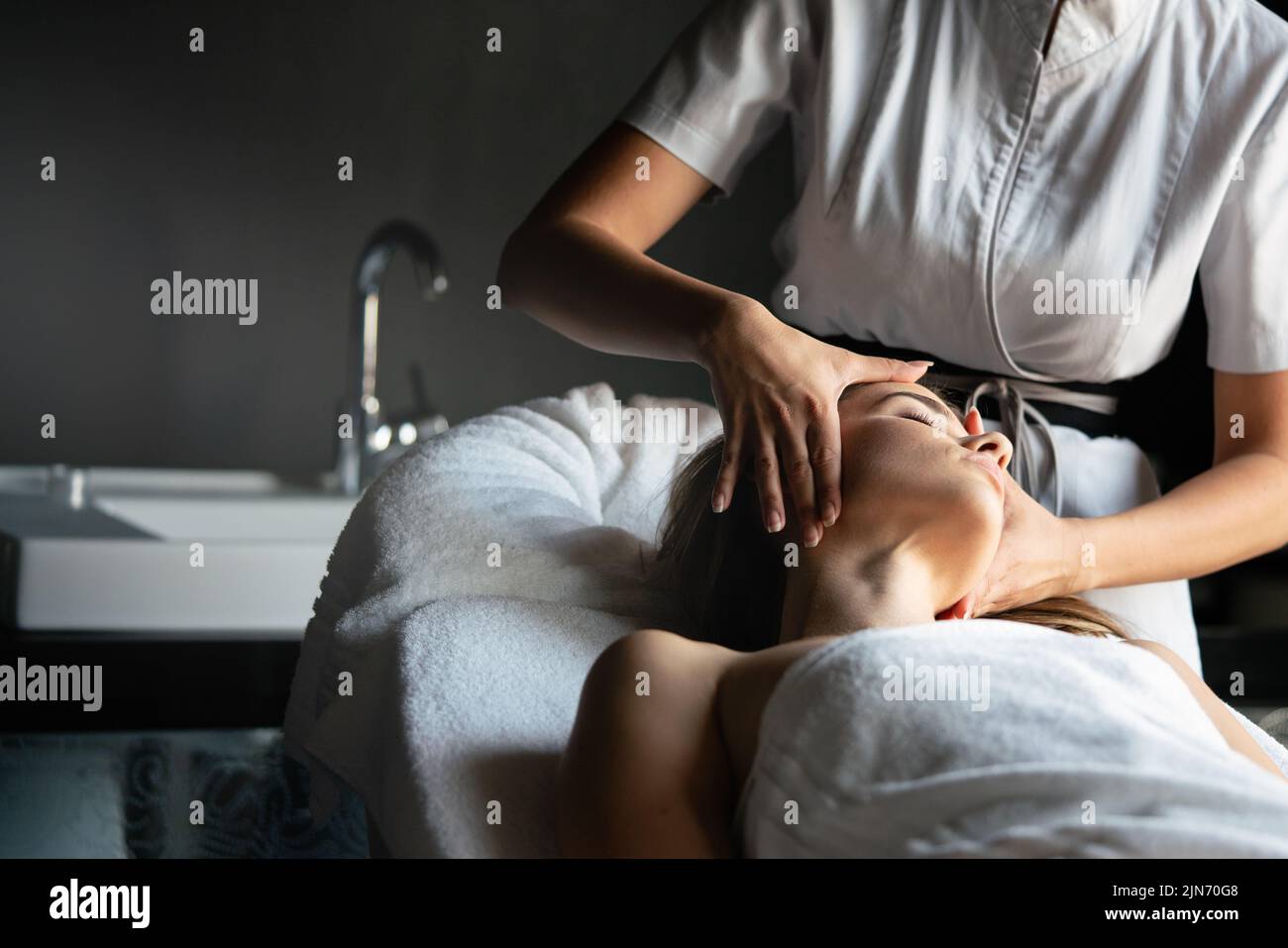 Concepto de salud, belleza, resort y relajación. Una mujer hermosa en el salón de spa recibiendo un masaje Foto de stock