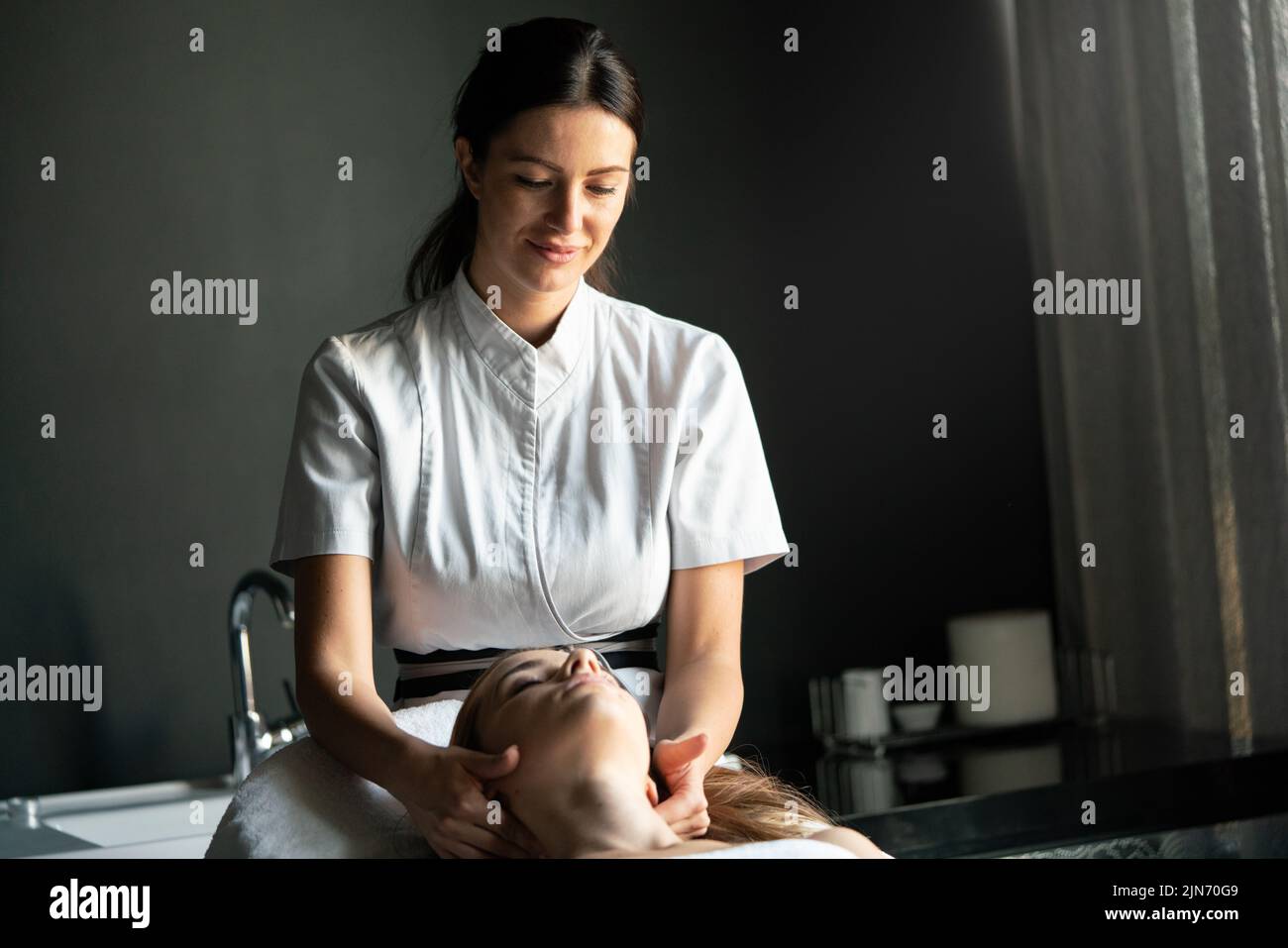 Concepto de bienestar, spa, salud y masaje - hermosa mujer que tiene un masaje en el salón Foto de stock