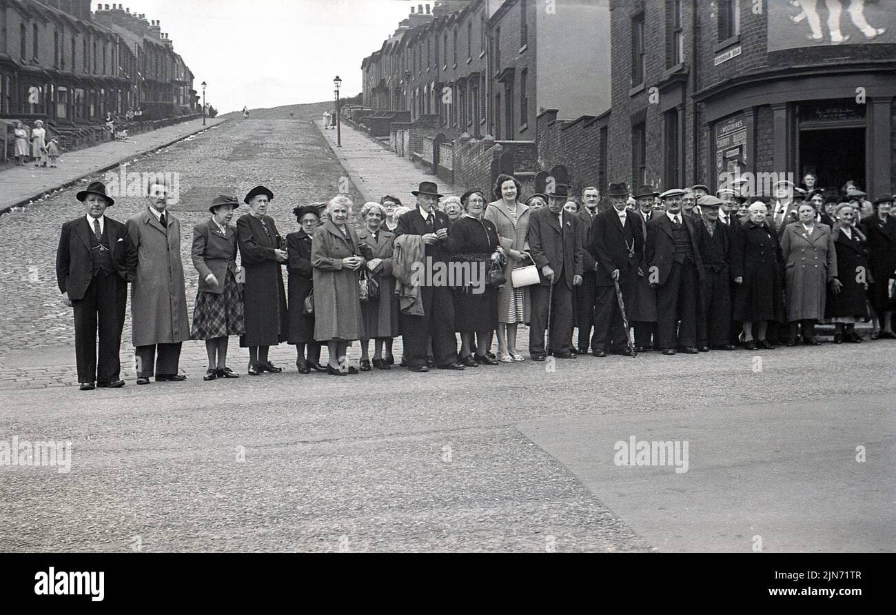 1950s h, histórico, viaje en autobús, de Sheffield a Tokay Express, Inglaterra, Reino Unido. Los pasajeros vestidos de forma inteligente se alinean en la calle para hacer una foto antes del viaje. Foto de stock
