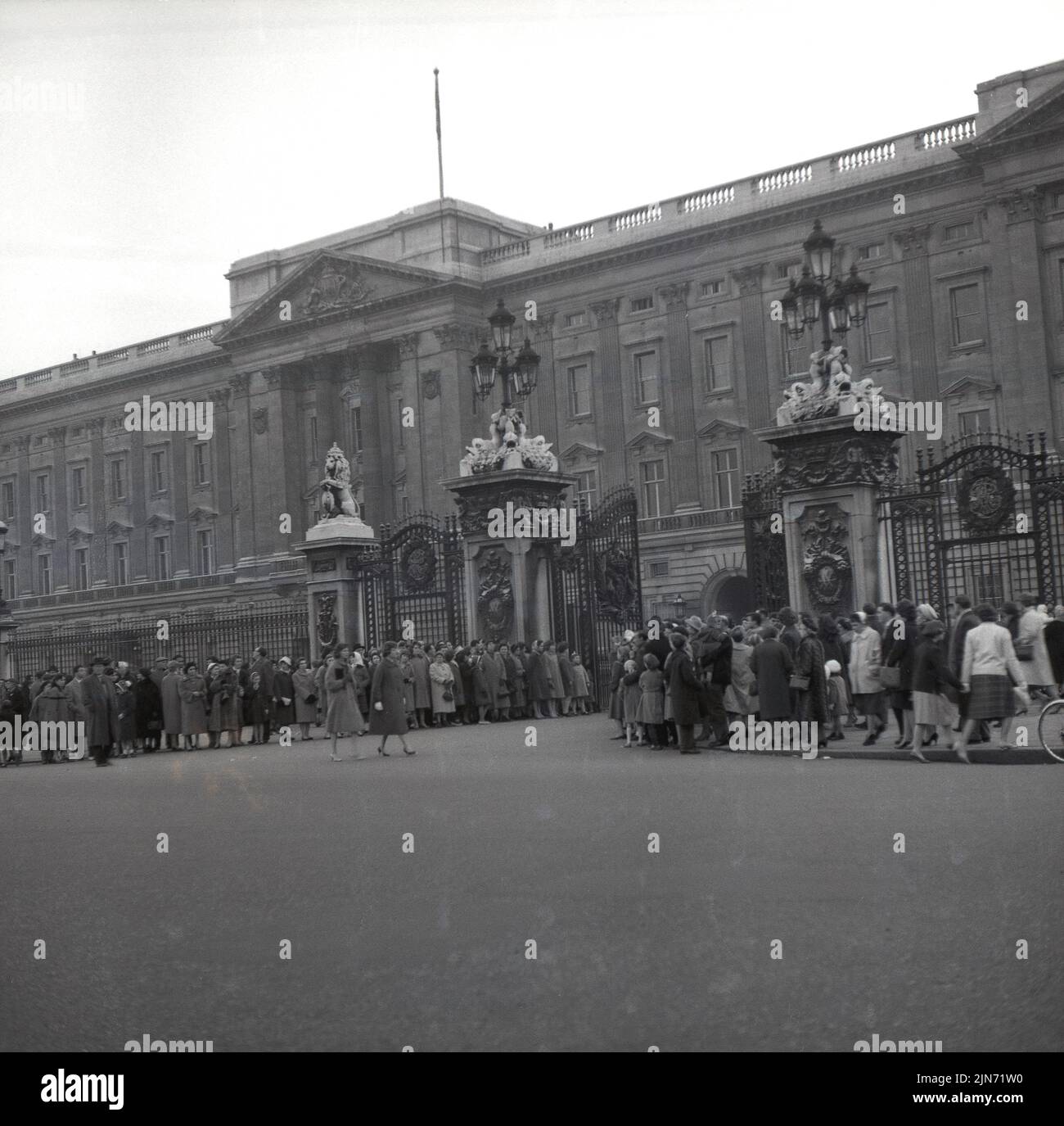 1950s, histórica, la gente se reunió en el exterior a las puertas del Palacio de Buckingham, la residencia londinense de la Familia Real Británica, Londres, Inglaterra, Reino Unido. Foto de stock