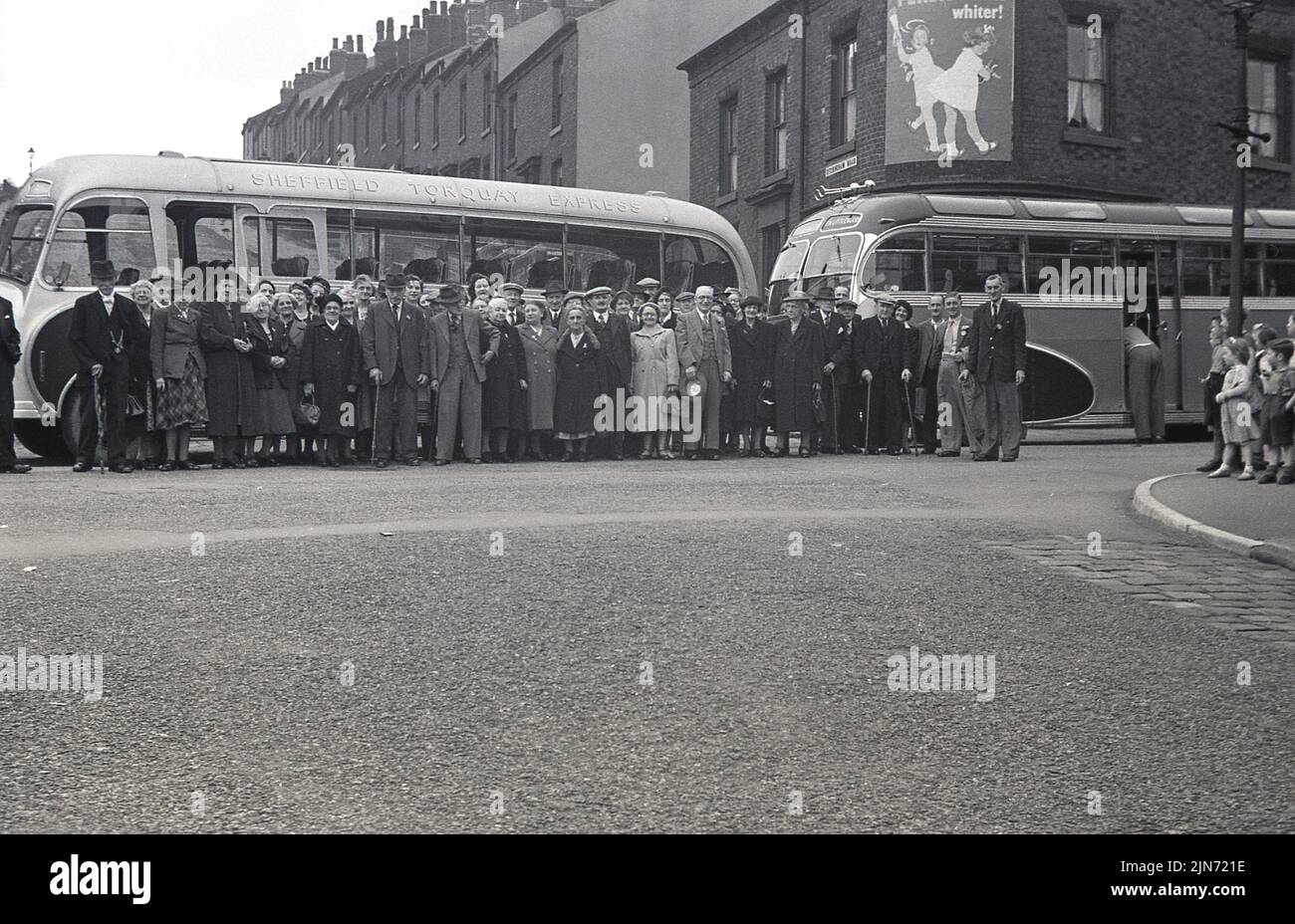 1950s h, histórico, viaje en autobús, de Sheffield a Torquay Express, Inglaterra, Reino Unido. Los pasajeros hacen cola en la calle para hacer una foto antes del viaje hacia el sur hasta la localidad costera de Torquay. Foto de stock