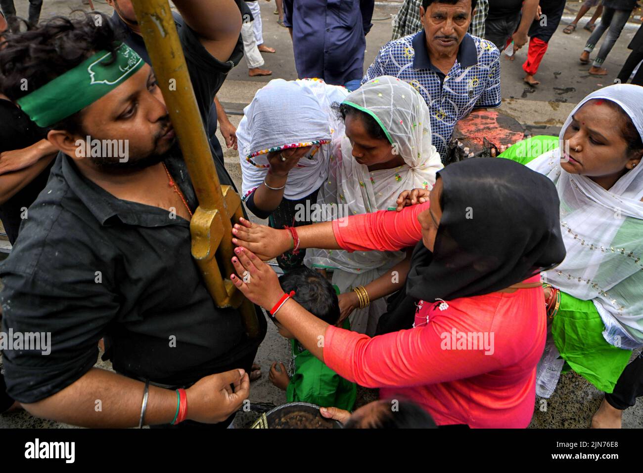 Los devotos musulmanes reciben bendiciones de la santa Tazia durante la procesión de Muharram en Kolkata. Muharram es el primer mes del calendario islámico y Ashura es el décimo día del mes de Muharram en el que se celebra la conmemoración del martirio del imán Hussain, nieto del profeta Mahoma (PBUH), durante la batalla de Karbala. Es parte del duelo por los musulmanes chiítas y un día de ayuno para los musulmanes sunitas que se observa en todo el mundo. Foto de stock