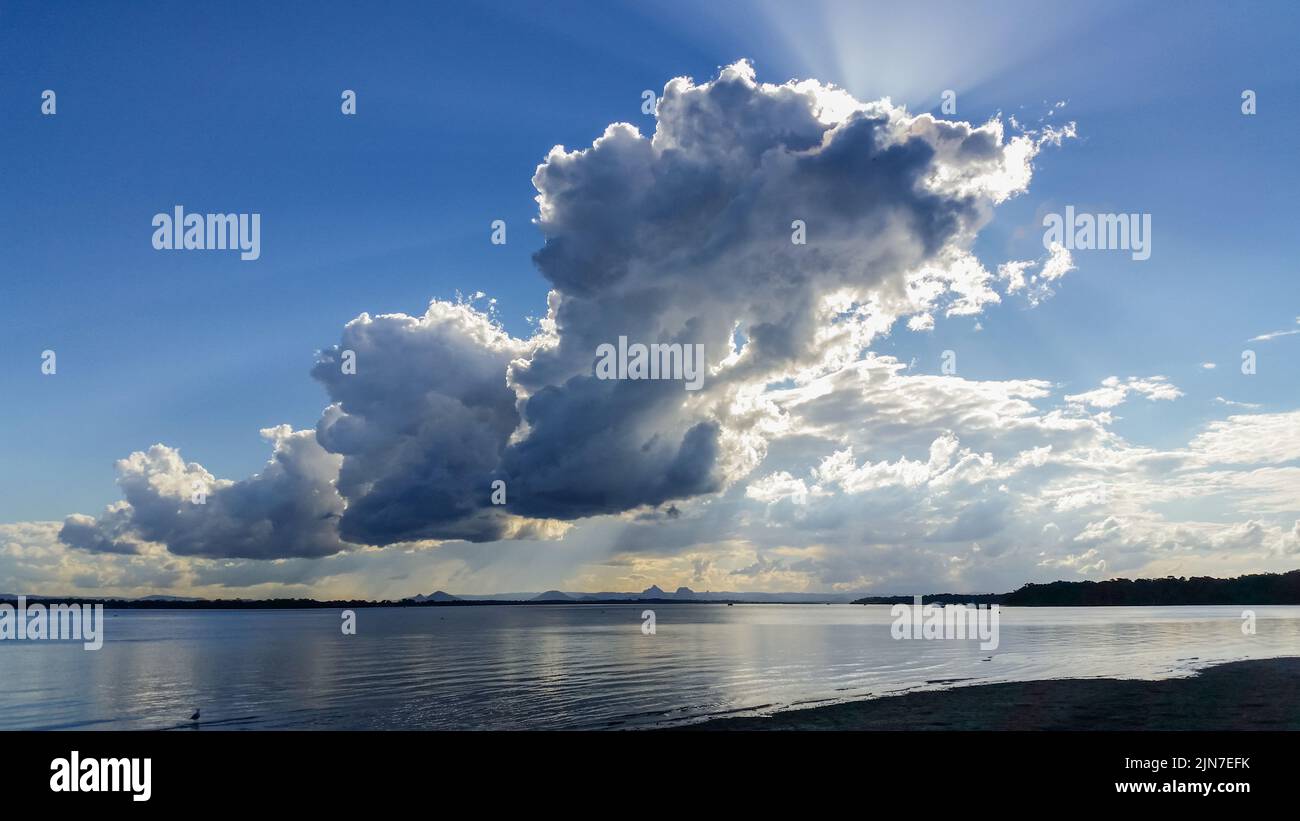 Nube de truenos sobre el paso de piedra pómez desde la isla de Bribie en Queensland, Australia, mirando sobre el agua hacia las montañas Glasshouse Foto de stock