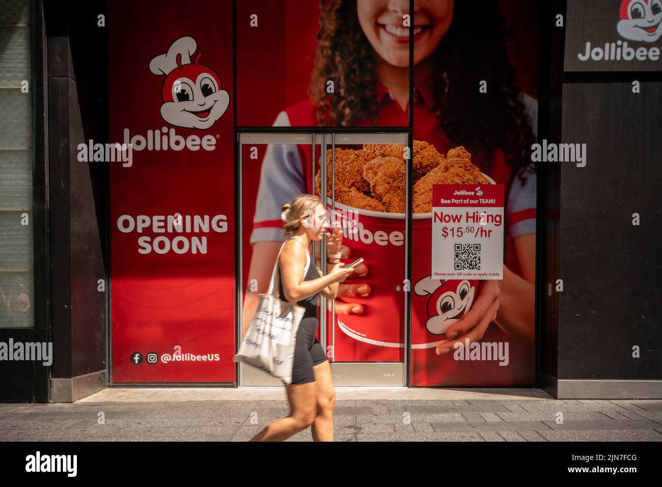 Un cartel en el exterior de la futura casa de un restaurante de comida rápida filipino Jollibee en Times Square en Nueva York anuncia que está contratando antes de su apertura el domingo, 31 de julio de 2022. (© Richard B. Levine) Foto de stock