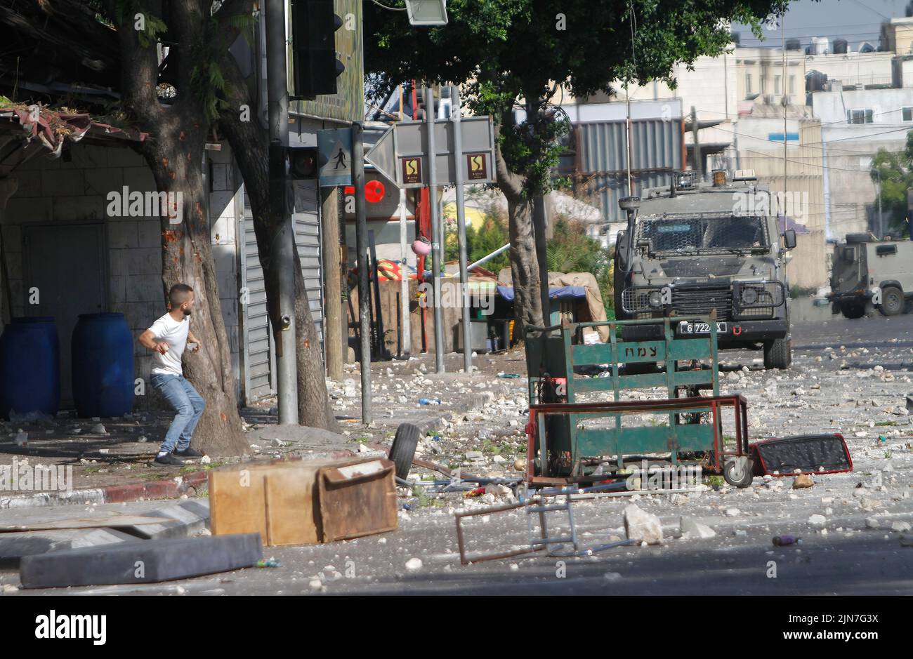 2 de agosto de 2022, Naplusa, Cisjordania, Palestina: Un manifestante palestino arroja piedras contra vehículos militares durante los enfrentamientos con las fuerzas del ejército israelí después de una redada en la Ciudad Vieja de Naplusa en la Cisjordania ocupada, el Ministerio de Salud palestino dijo que 3 palestinos murieron durante la redada. (Imagen de crédito: © Nasser Ishtayeh/imágenes SOPA a través DE ZUMA Press Wire) Foto de stock