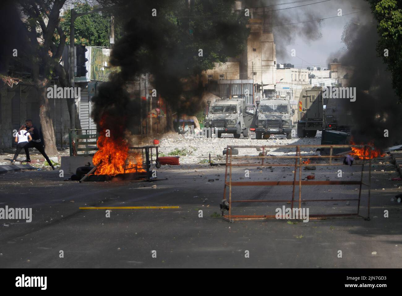 2 de agosto de 2022, Nablus, Cisjordania, Palestina: Manifestantes palestinos queman neumáticos y arrojan piedras a vehículos militares durante los enfrentamientos con las fuerzas del ejército israelí Después de una incursión en la Ciudad Vieja de Nablus en la ocupada Cisjordania, el Ministerio de Salud palestino dijo que 3 palestinos murieron durante la incursión. (Imagen de crédito: © Nasser Ishtayeh/imágenes SOPA a través DE ZUMA Press Wire) Foto de stock