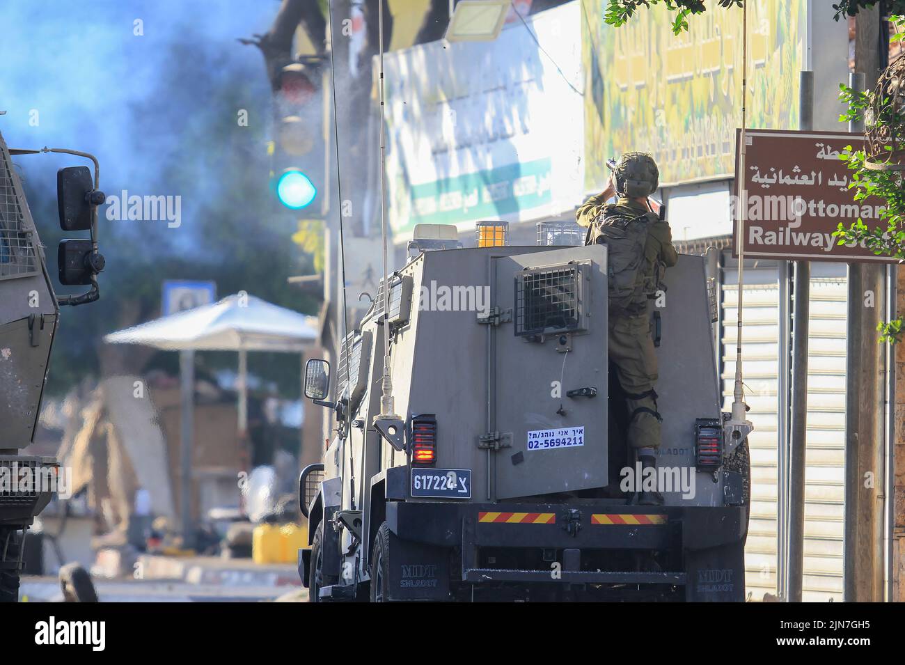 2 de agosto de 2022, Nablus, Cisjordania, Palestina: Un soldado israelí dispara botes de gas lacrimógeno detrás de un vehículo militar durante los enfrentamientos con las fuerzas del ejército israelí Después de una incursión en la Ciudad Vieja de Naplusa en la Cisjordania ocupada, el Ministerio de Salud palestino dijo que 3 palestinos murieron durante la incursión. (Imagen de crédito: © Nasser Ishtayeh/imágenes SOPA a través DE ZUMA Press Wire) Foto de stock