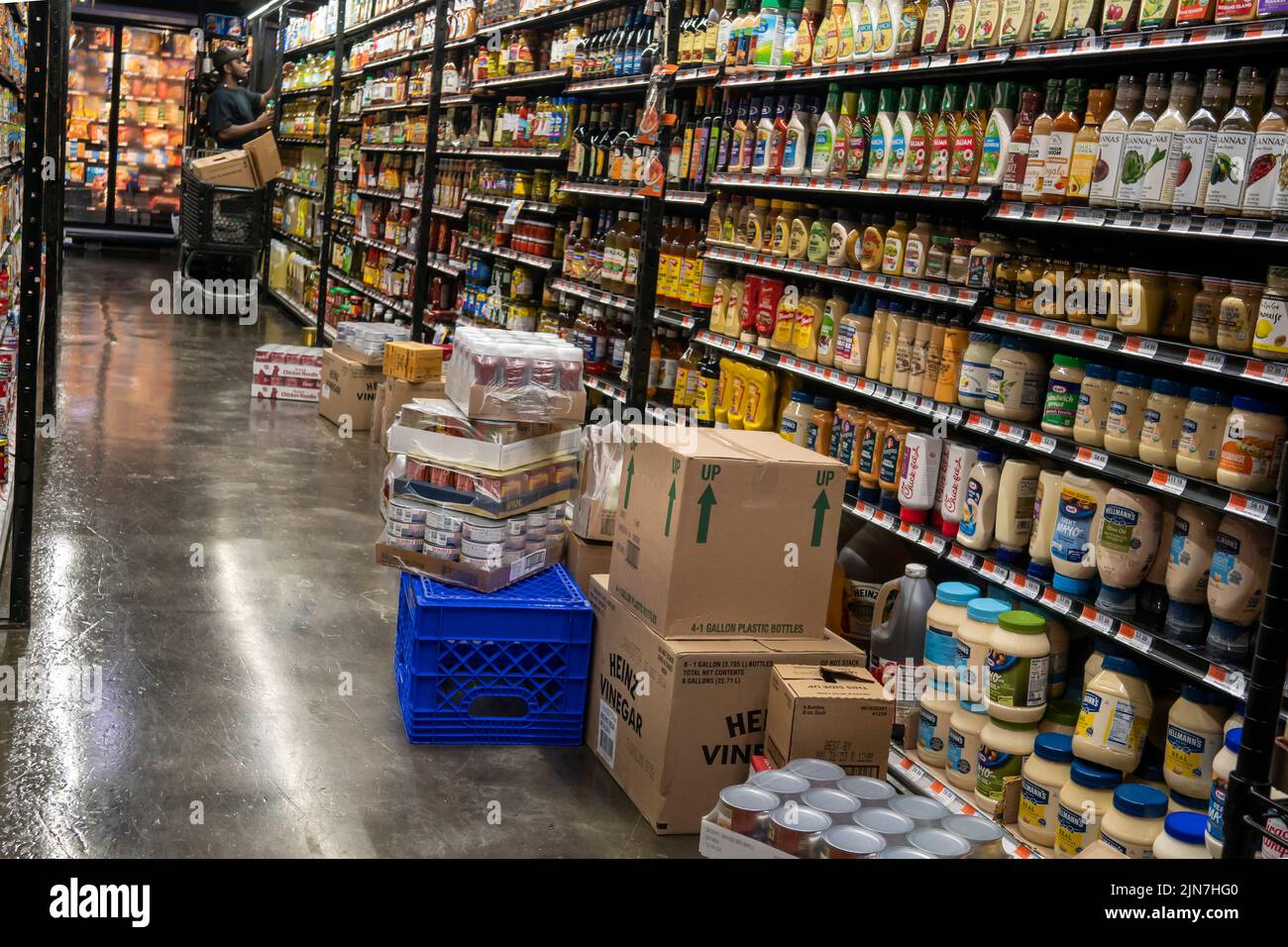 Un trabajador abastece un supermercado en Nueva York el lunes, 25 de julio de 2022. El informe sobre el producto interno bruto del segundo trimestre predice que Estados Unidos acaba de pasar por alto una recesión. (© Richard B. Levine) Foto de stock