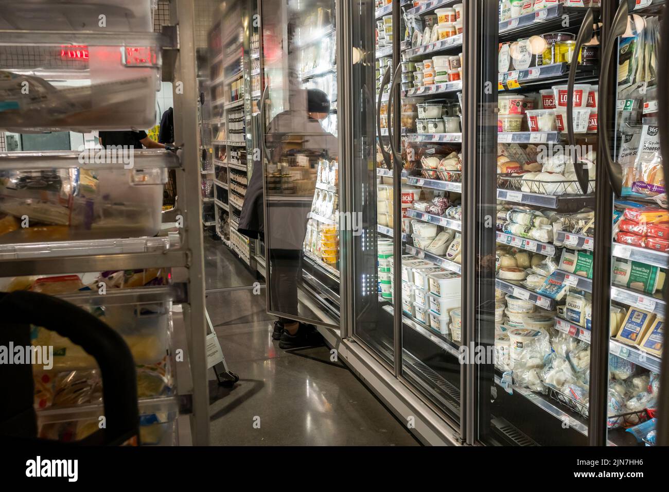 Un trabajador abastece un refrigerador de productos lácteos en un supermercado Whole Foods Market en Nueva York el martes, 26 de julio de 2022. El informe sobre el producto interno bruto del segundo trimestre predice que Estados Unidos acaba de pasar por alto una recesión. (© Richard B. Levine) Foto de stock