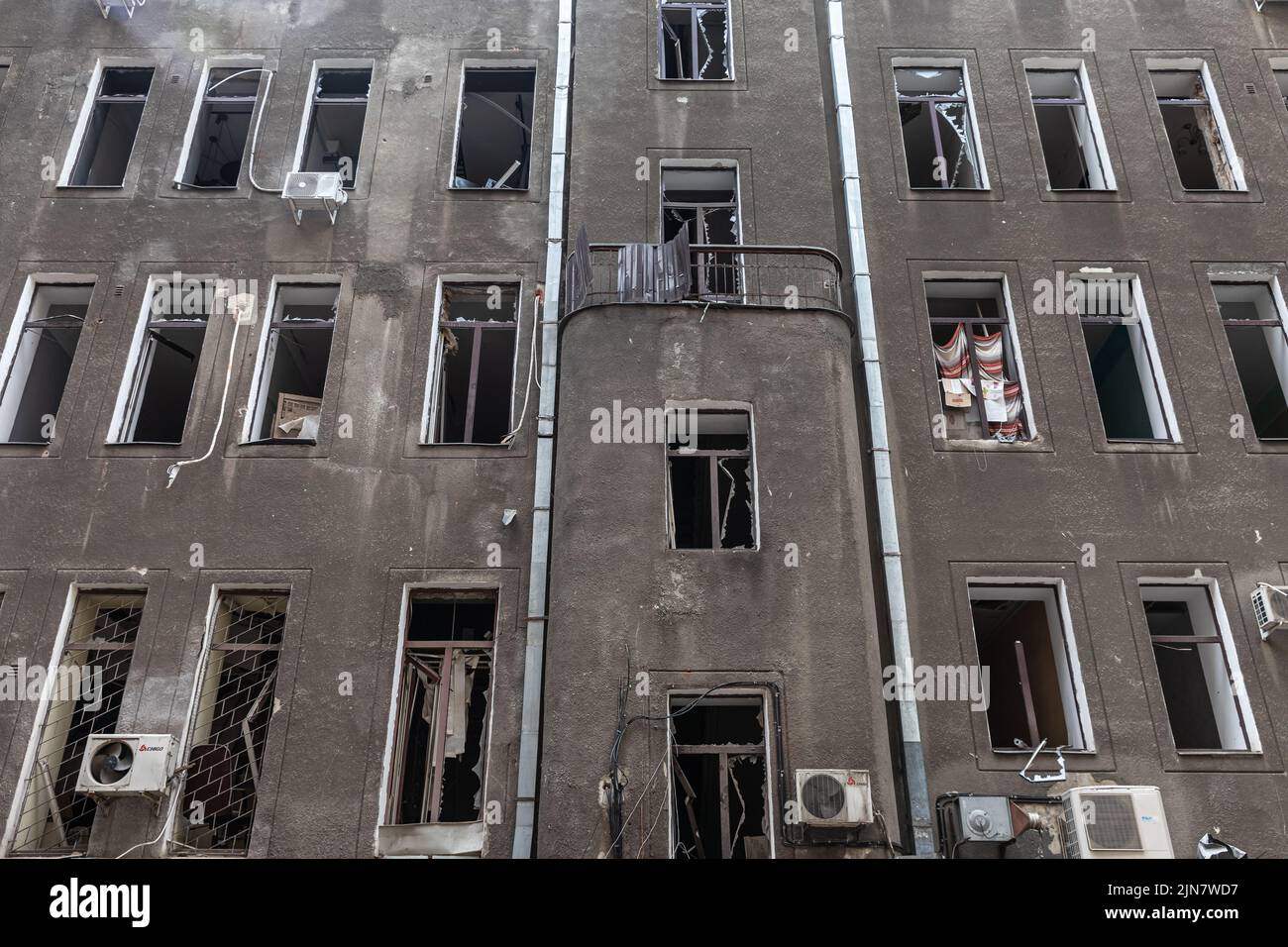 Puertas y ventanas rotas en los locales de un edificio histórico. Edificio destruido en el centro histórico en Kharkiv, Ucrania - 1 Ago 2022 Foto de stock