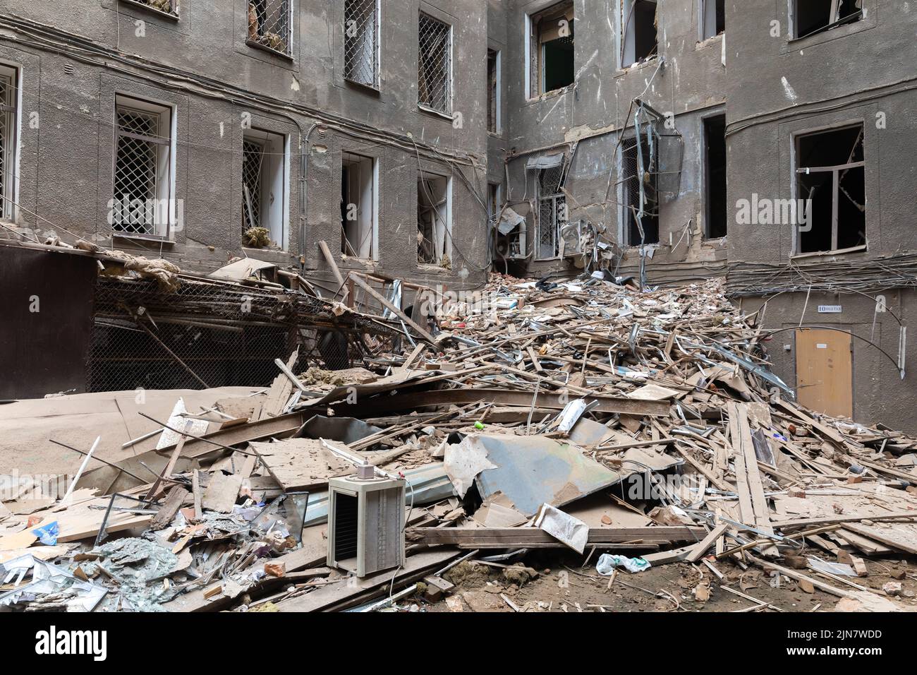 Ventanas rotas en los locales de un edificio histórico. Edificio destruido en el centro histórico en Kharkiv, Ucrania - 1 Ago 2022 Foto de stock