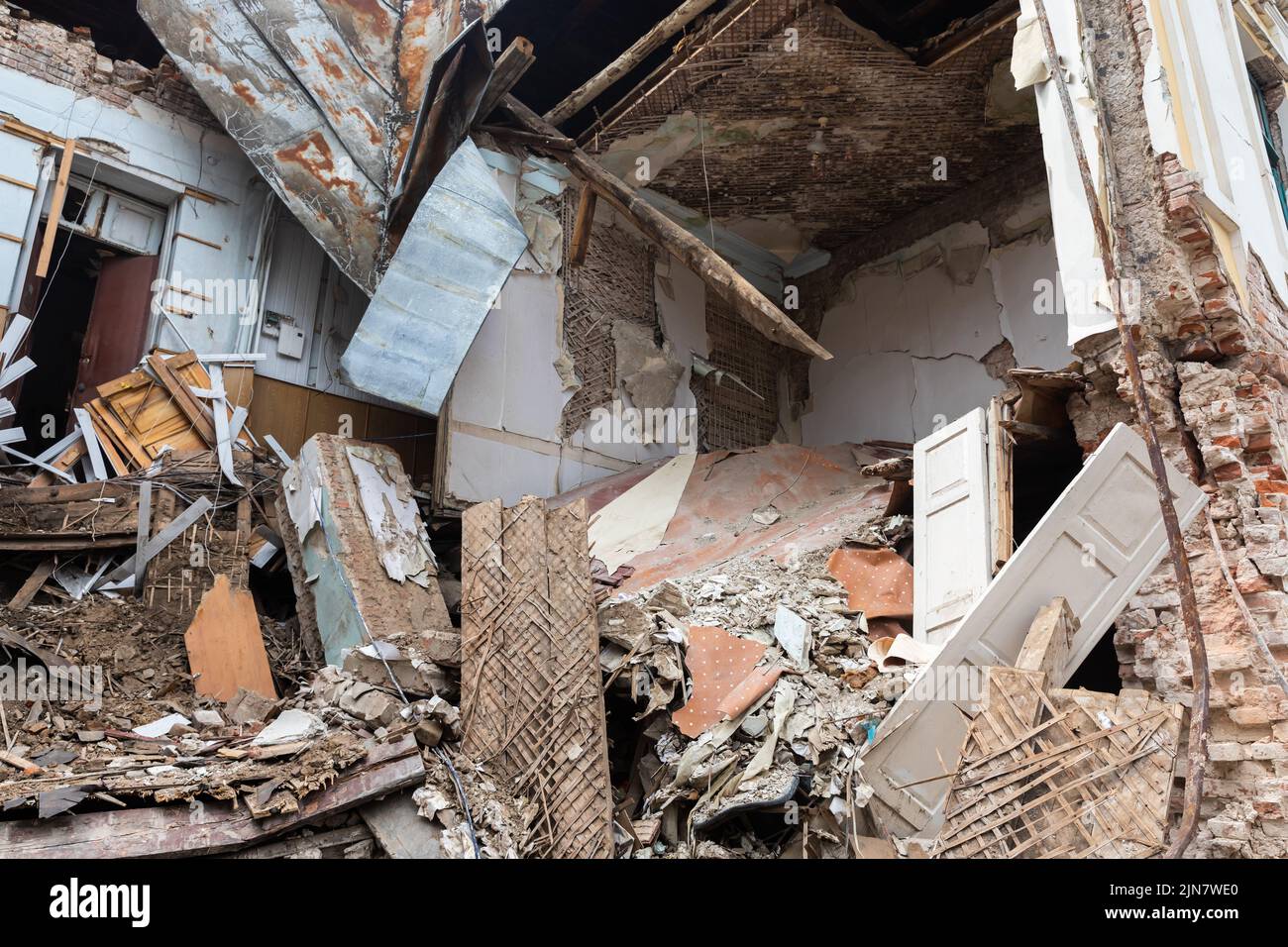 Un apartamento en ruinas, y fragmentos de estructuras de edificios están esparcidos por todas partes. Edificio destruido en el centro histórico en Kharkiv, Ucrania - 1 Ago 2022 Foto de stock