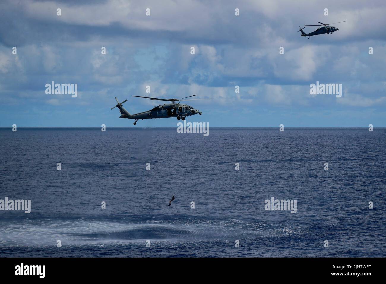 220807-N-CH260-1433 OCÉANO PACÍFICO (AGOSTO 7, 2022) Dos helicópteros MH-60s Sea Hawk, ambos asignados a los “Chargers” del Escuadrón de Combate Marítimo de Helicópteros (HSC) 14, realizan una búsqueda simulada y rescate junto al portaaviones de clase Nimitz USS Abraham Lincoln (CVN 72) durante una demostración de potencia aérea para los huéspedes embarcados. El Abraham Lincoln Carrier Strike Group está llevando a cabo operaciones rutinarias en la Flota 3rd de los Estados Unidos. (EE. UU Foto de la Marina por el Especialista en Comunicación de Masas 3rd Clase Kassandra Alanis) Foto de stock