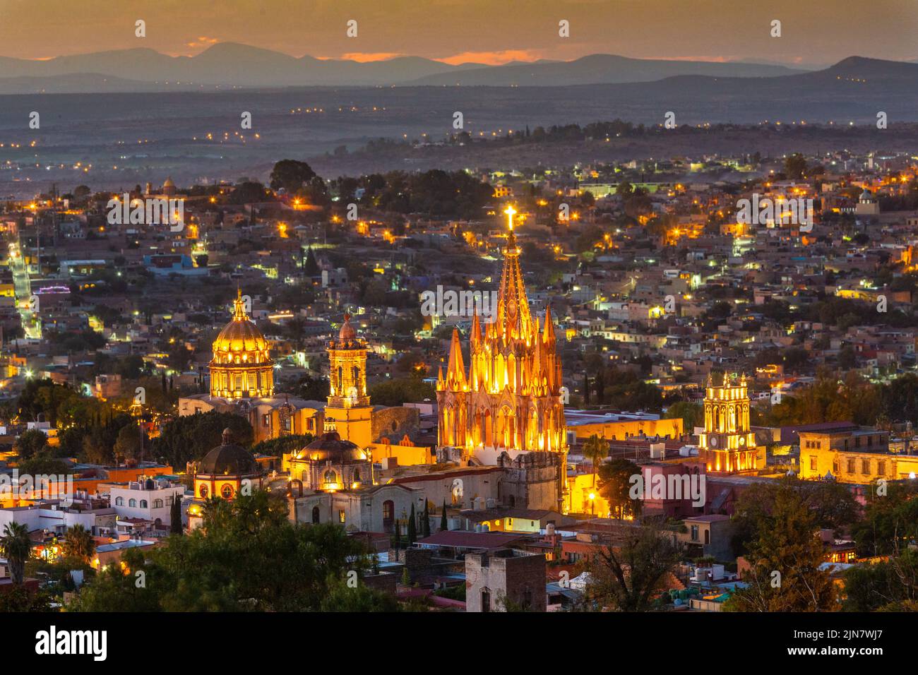 Colorida puesta de sol sobre la Parroquia de San Miguel Arcangel y las torres de la iglesia de San Francisco en el distrito histórico visto desde el barrio de Los Balcones en San Miguel de Allende, México. Foto de stock