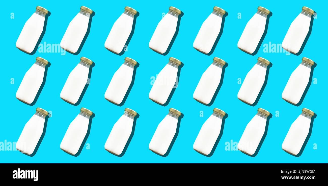 Botella de leche de fondo mínimo. Muchas botellas de vidrio de leche blanca de vaca o yogur en un patrón. Fotografía de alta calidad Foto de stock
