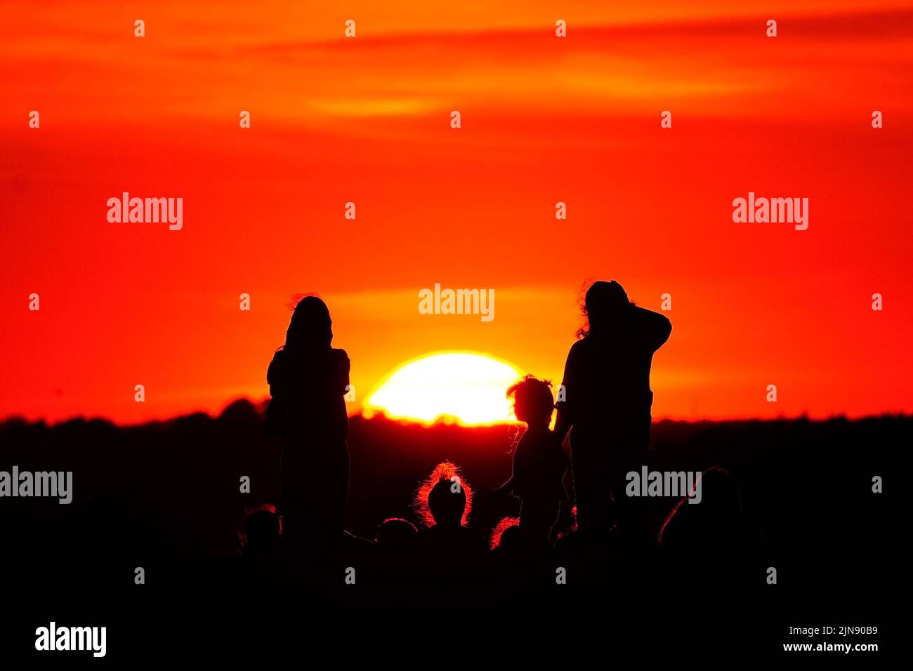 Un grupo de personas observa la puesta de sol desde una colina en Ealing, al oeste de Londres, mientras continúa un verano de prohibiciones de tubos de escape y advertencias de incendio, con una alerta de salud por calor que se está implantando en gran parte del país. Fecha de la foto: Martes 9 de agosto de 2022. Foto de stock