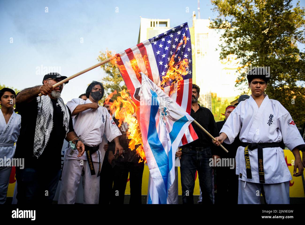Dos hombres queman las banderas de Estados Unidos e Israel durante una manifestación de protesta contra Israel en el centro de Teherán, Irán, el 9 de agosto de 2022. (Foto de Sobhan Farajvan / Pacific Press/Sipa USA) Foto de stock
