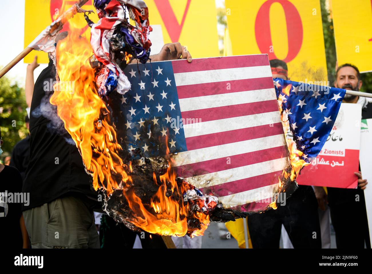 Un hombre quema la bandera de los Estados Unidos durante una reunión de protesta contra Israel en el centro de Teherán, Irán, el 9 de agosto de 2022. (Foto de Sobhan Farajvan / Pacific Press/Sipa USA) Foto de stock