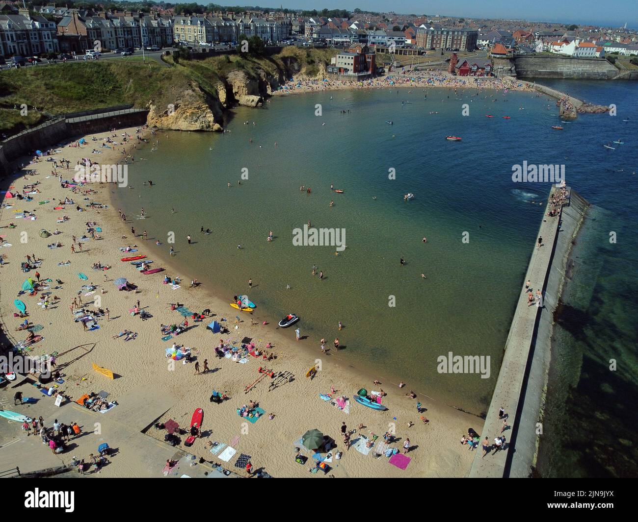 Una vista aérea de la gente disfrutando del clima caluroso en la playa de la bahía de Cullercoats en North Tyneside. La Oficina del MET ha emitido una advertencia ámbar sobre las condiciones de calor extremo que cubre cuatro días, de jueves a domingo, en algunas partes de Inglaterra y Gales a medida que se avecina una nueva ola de calor. Fecha de la foto: Miércoles 10 de agosto de 2022. Foto de stock