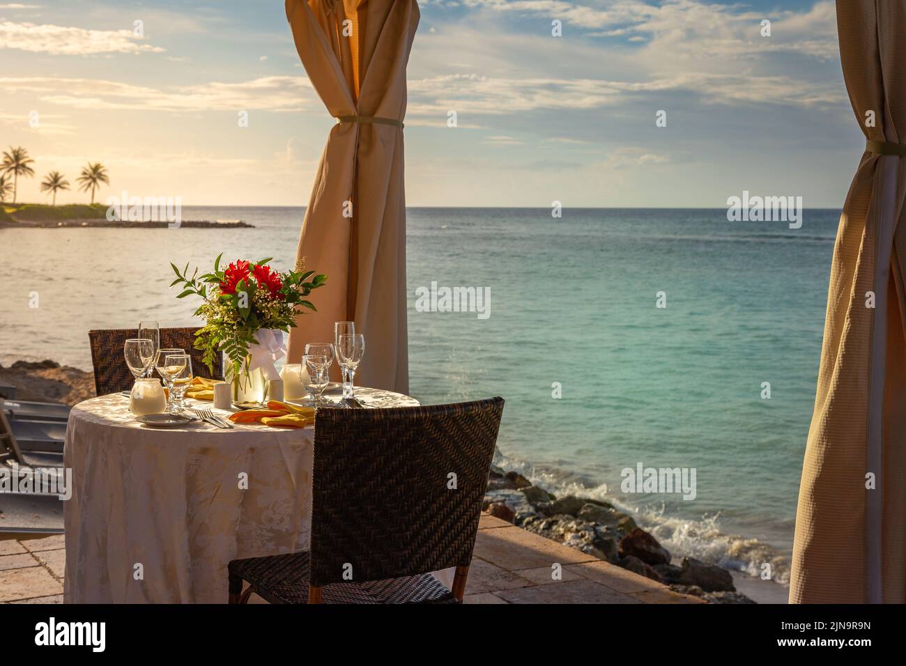 Mesa romántica para dos y playa con cenador al atardecer, Montego Bay, Jamaica Foto de stock