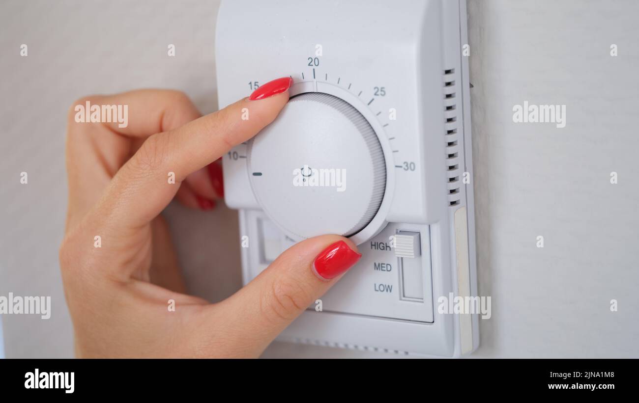 Mano en el controlador de temperatura de calefacción, control del radiador,  termostato del radiador, calor, calefacción, costos de energía, termostato,  radiador, ahorro de energía Fotografía de stock - Alamy